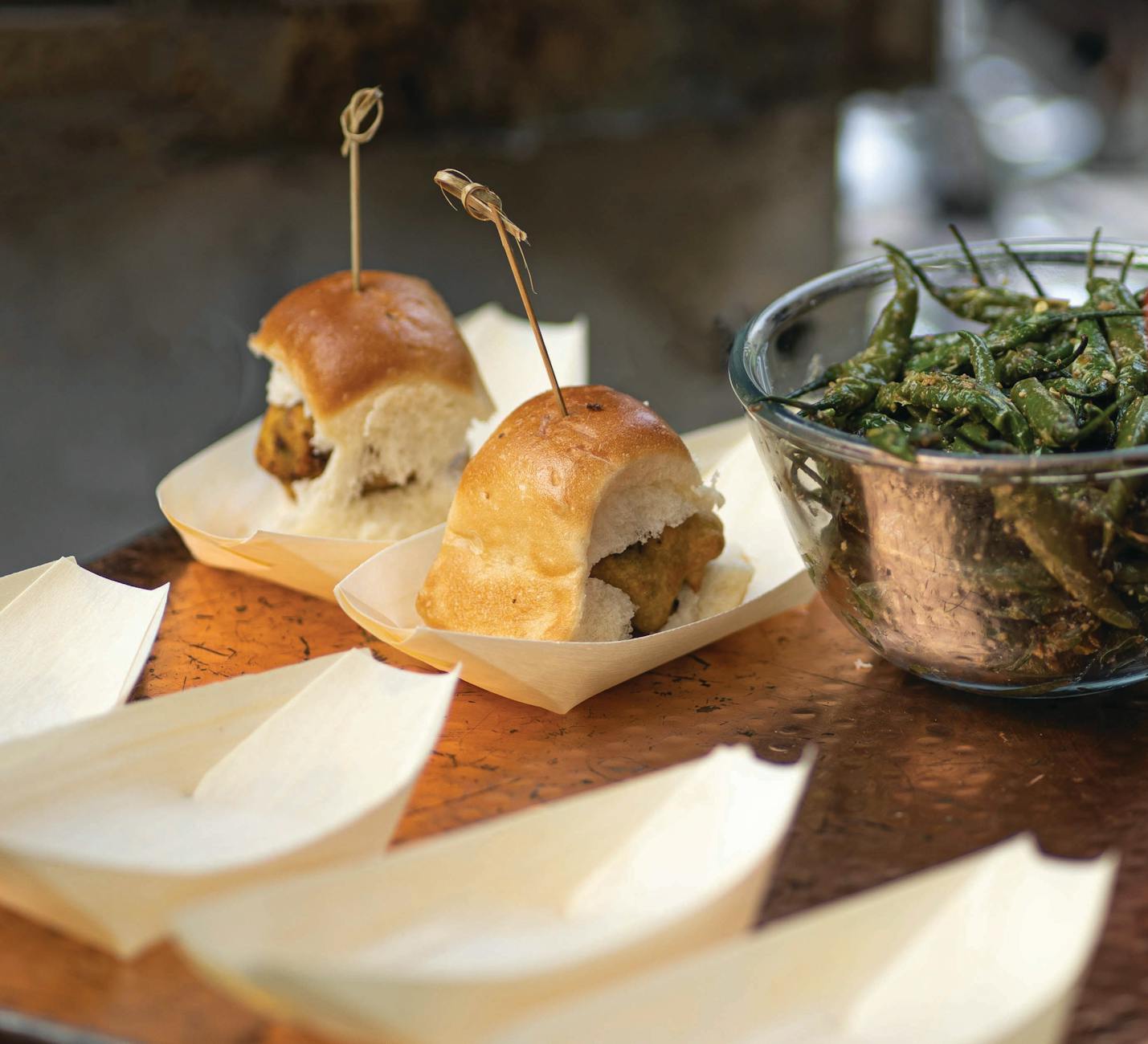 Vada pav served with fried green chilies, a popular Indian street food, captured in New Delhi.