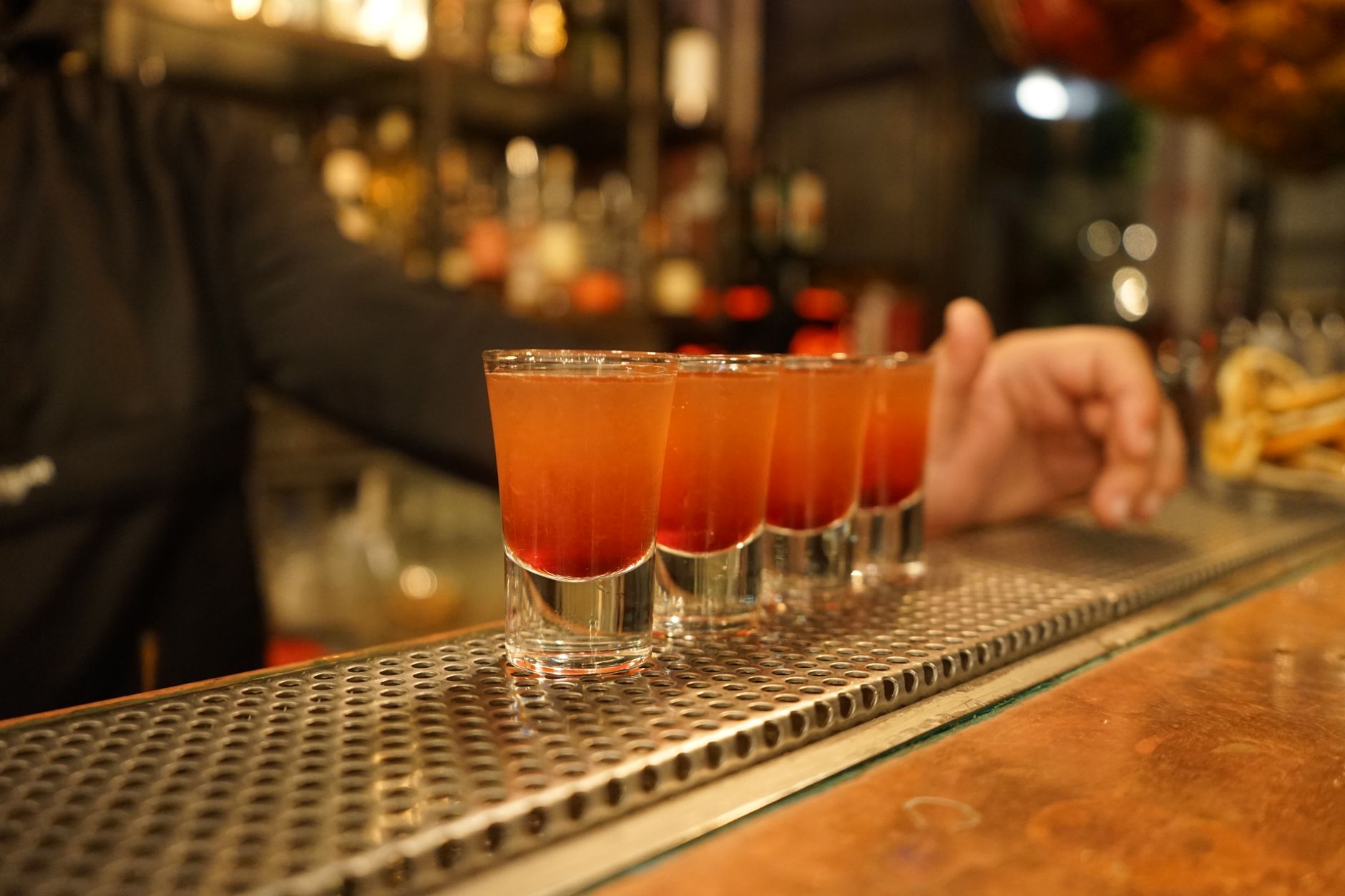 Colorful cocktail shots ready on a bar counter, capturing nightlife and bar atmosphere.