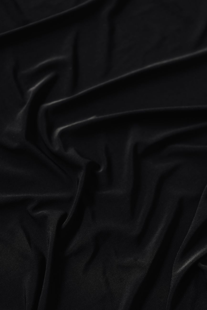 Close-up of elegant black fabric with intricate folds, perfect for design backgrounds.
