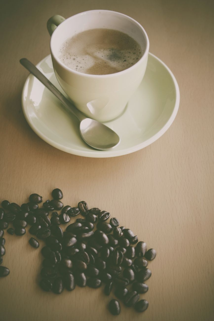 Warm coffee scene with a mug and coffee beans on a table.