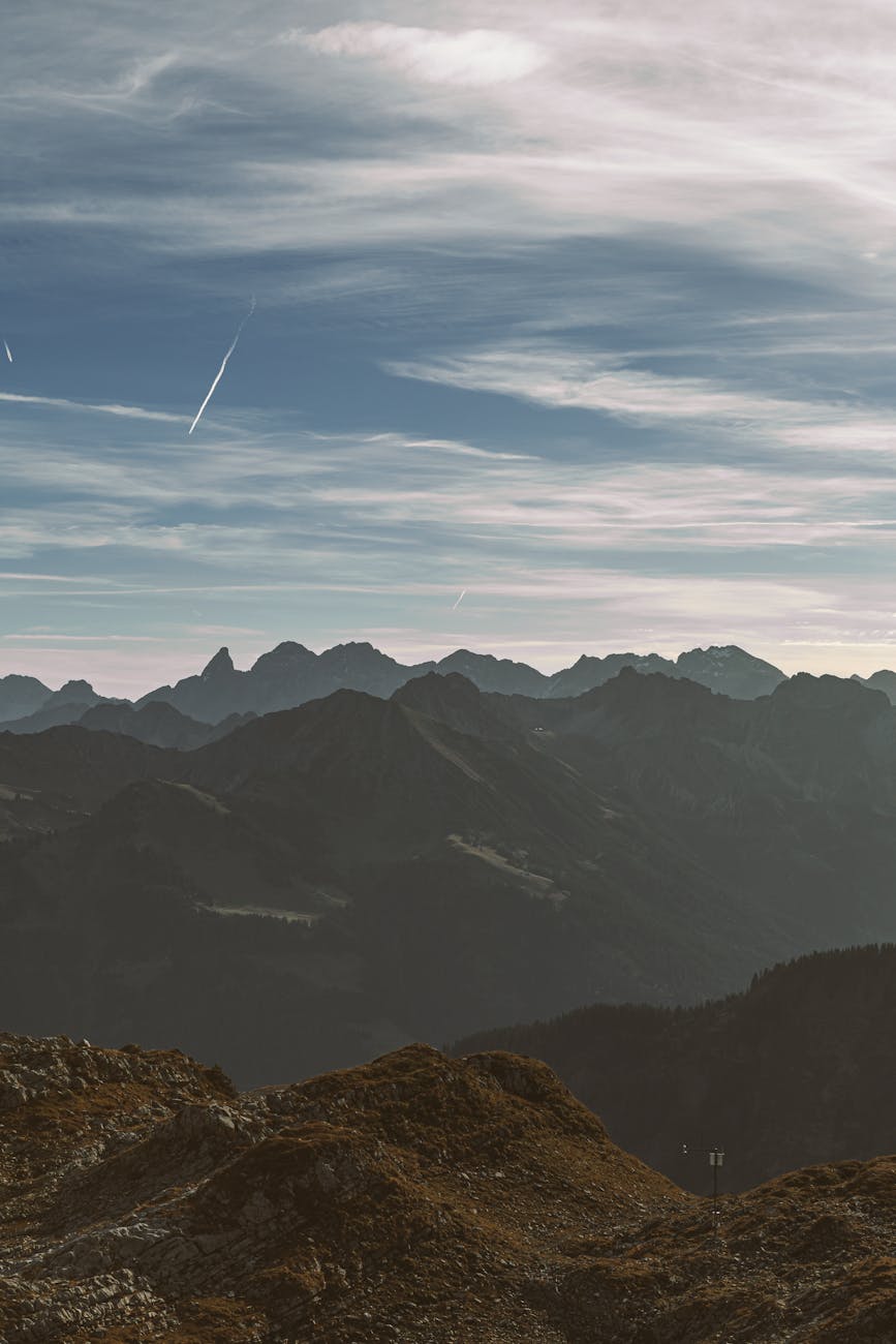 A breathtaking view of a foggy mountain range under a misty evening sky.