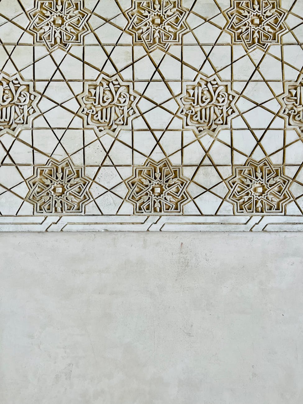 Detailed geometric patterns on a textured wall showcasing Islamic art in a vertical shot.