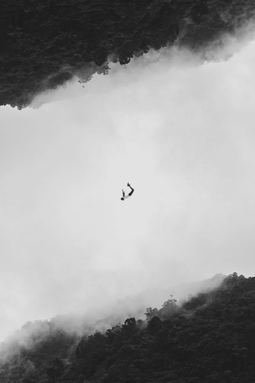 Silhouetted person mid-air against a fog and forest backdrop in Shiding District, Taiwan.