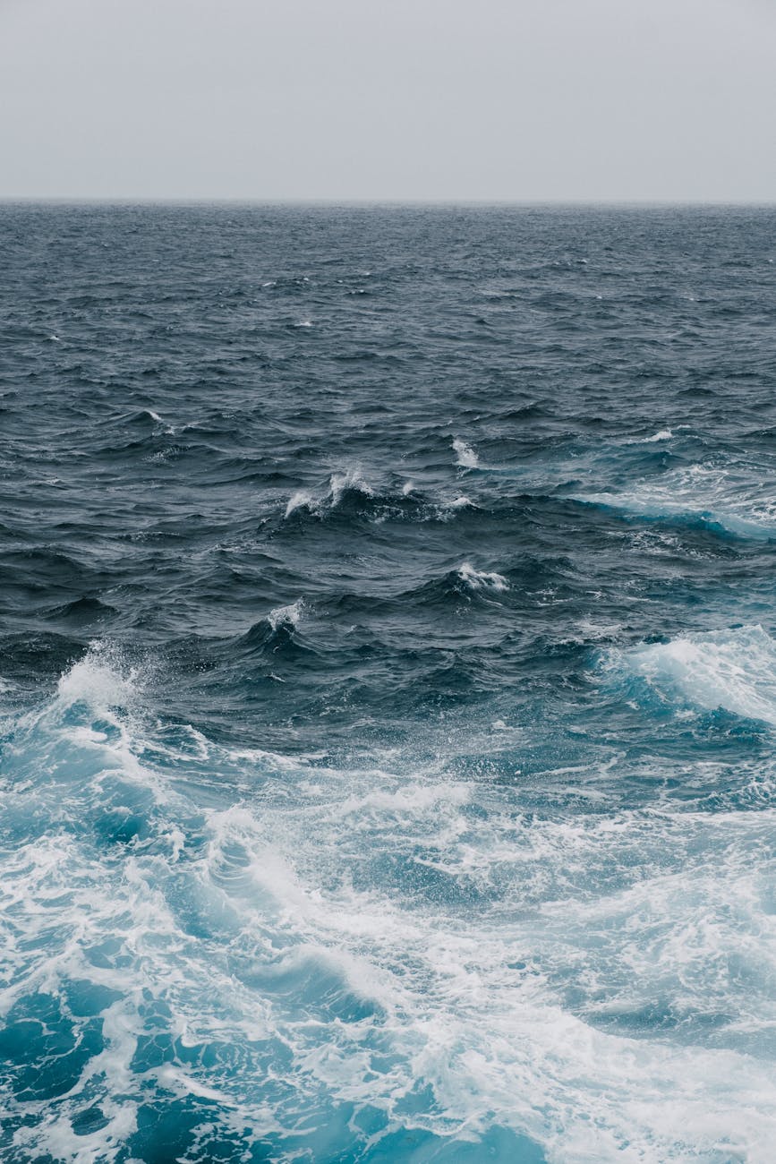 Experience the raw power of the ocean as waves crash under a cloudy sky, showcasing nature's dynamic beauty.