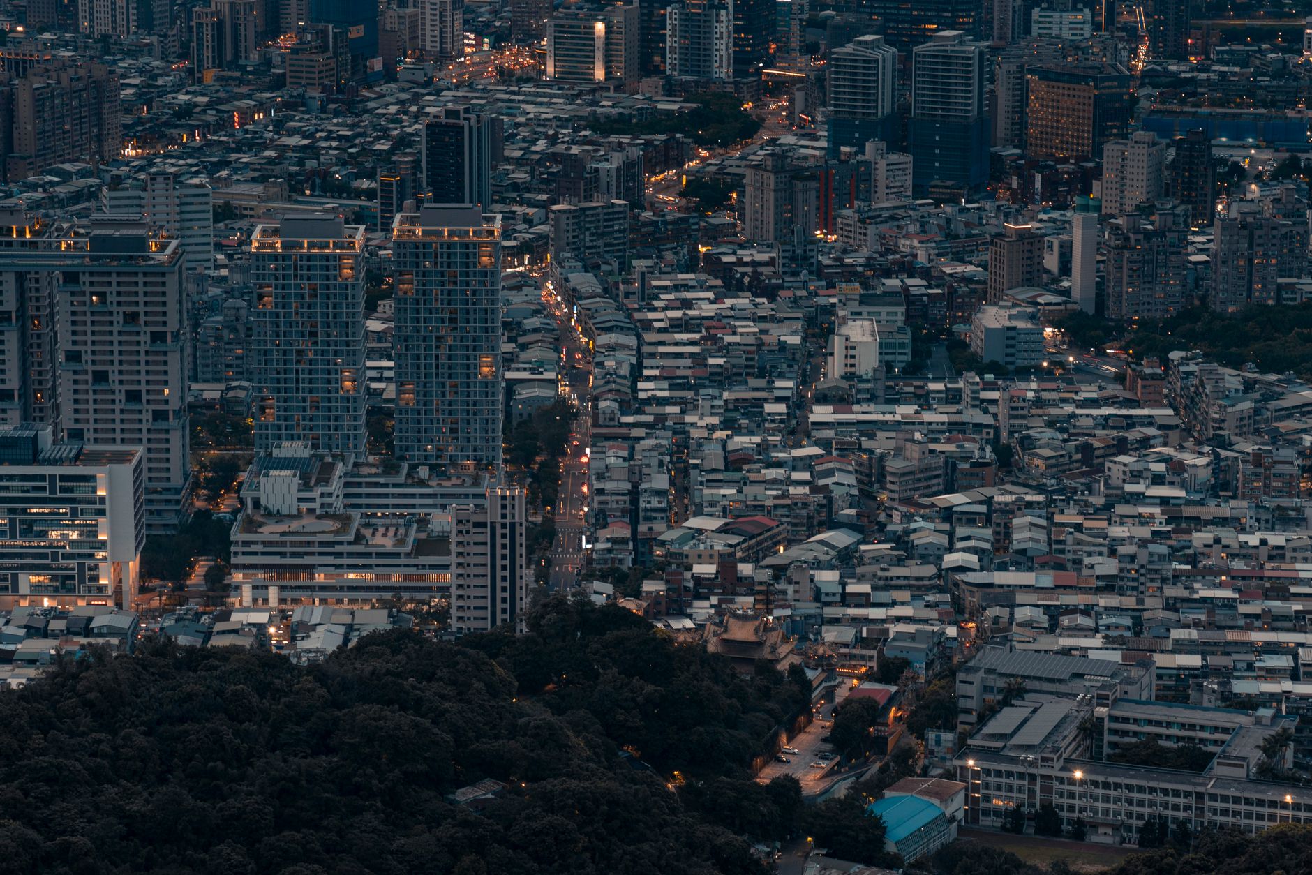 A stunning aerial cityscape of Taipei showcasing urban development and architecture at dusk.