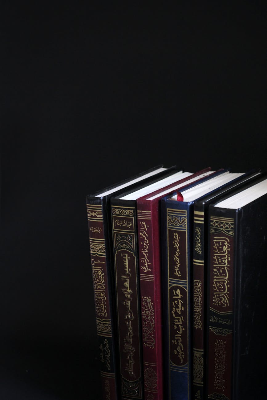 A collection of Arabic books arranged vertically on a black background.