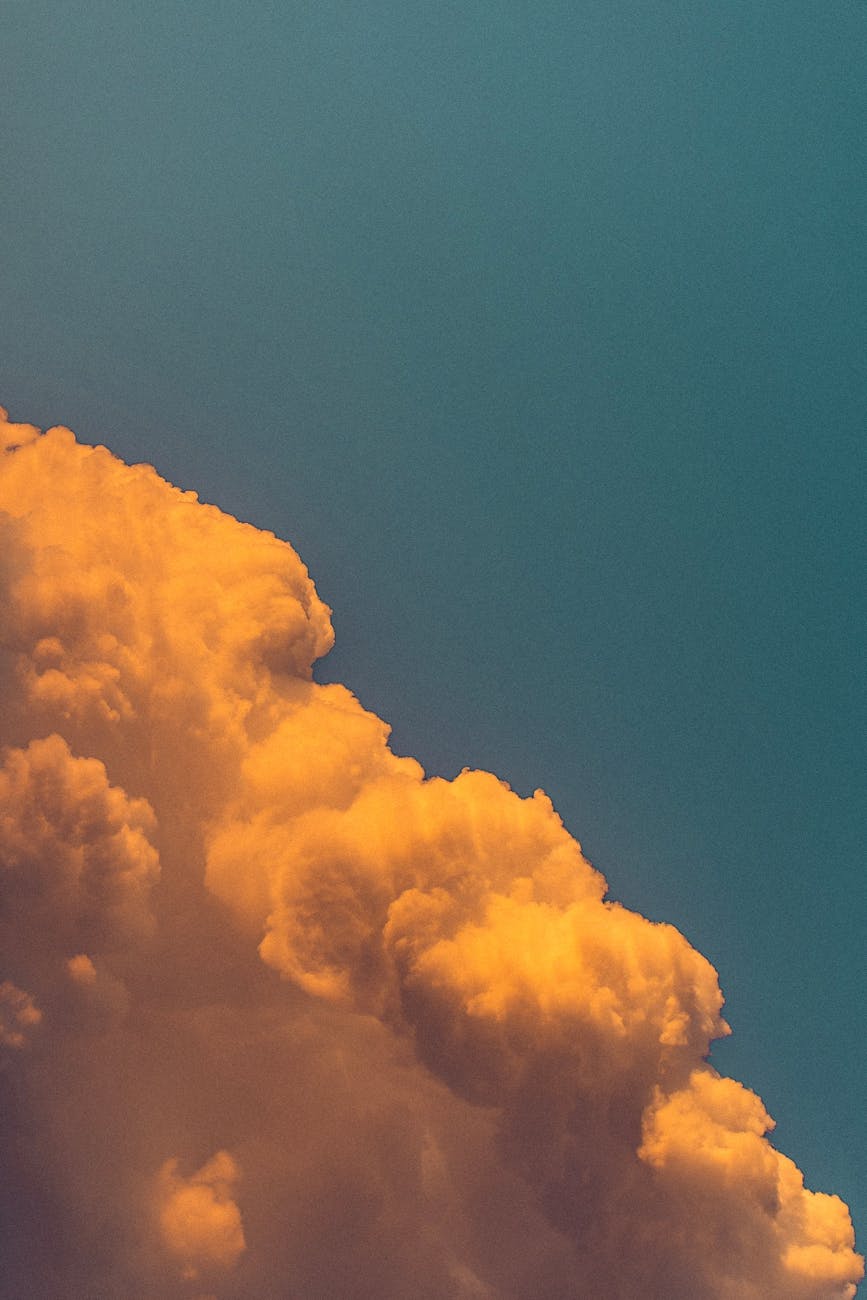 Close-up of fluffy golden clouds against a deep blue sky, showcasing a stunning natural contrast.