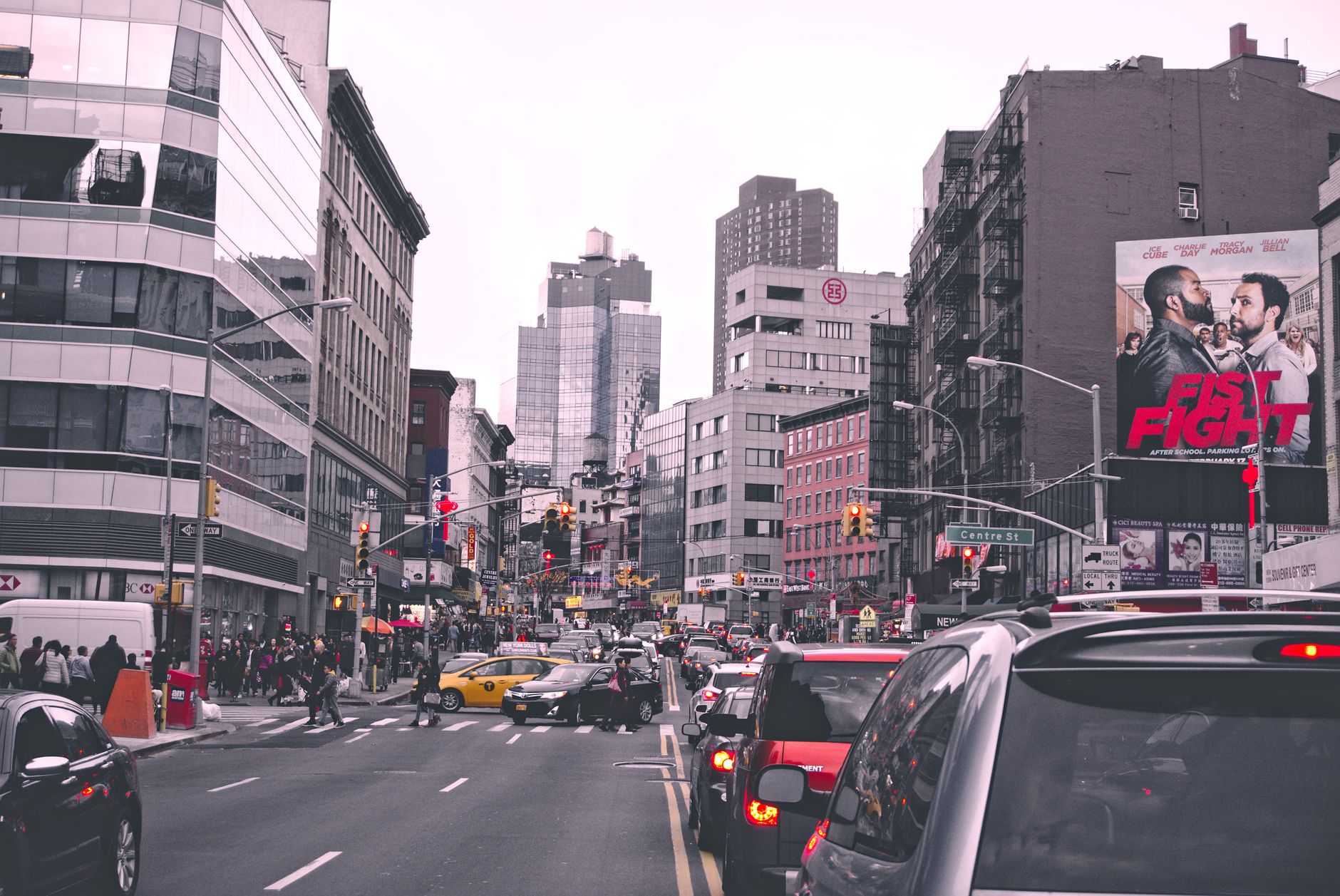 Lively city street in New York with bustling traffic and urban buildings during the day.