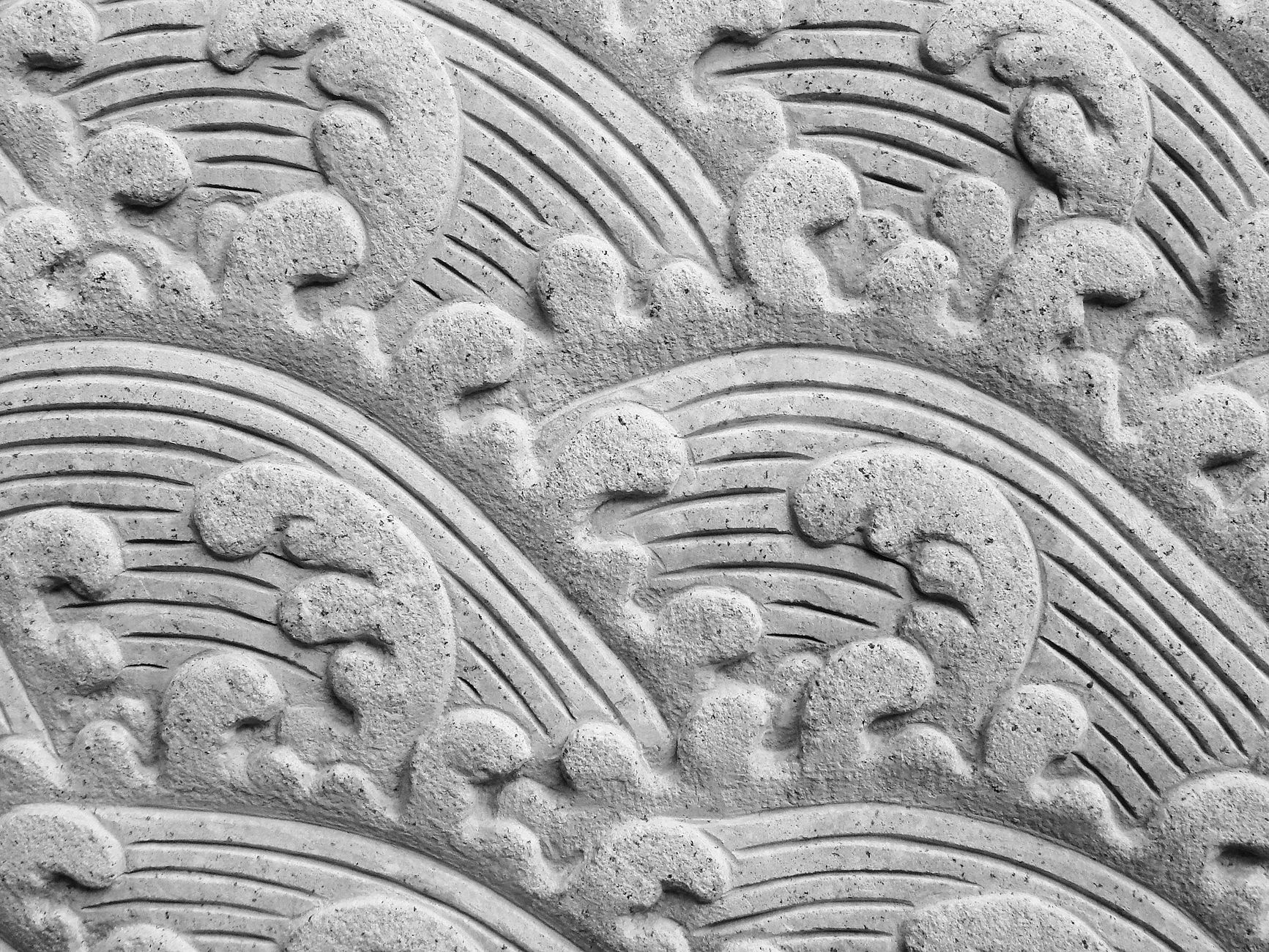 Detailed stone carving depicting elegant ocean wave patterns.
