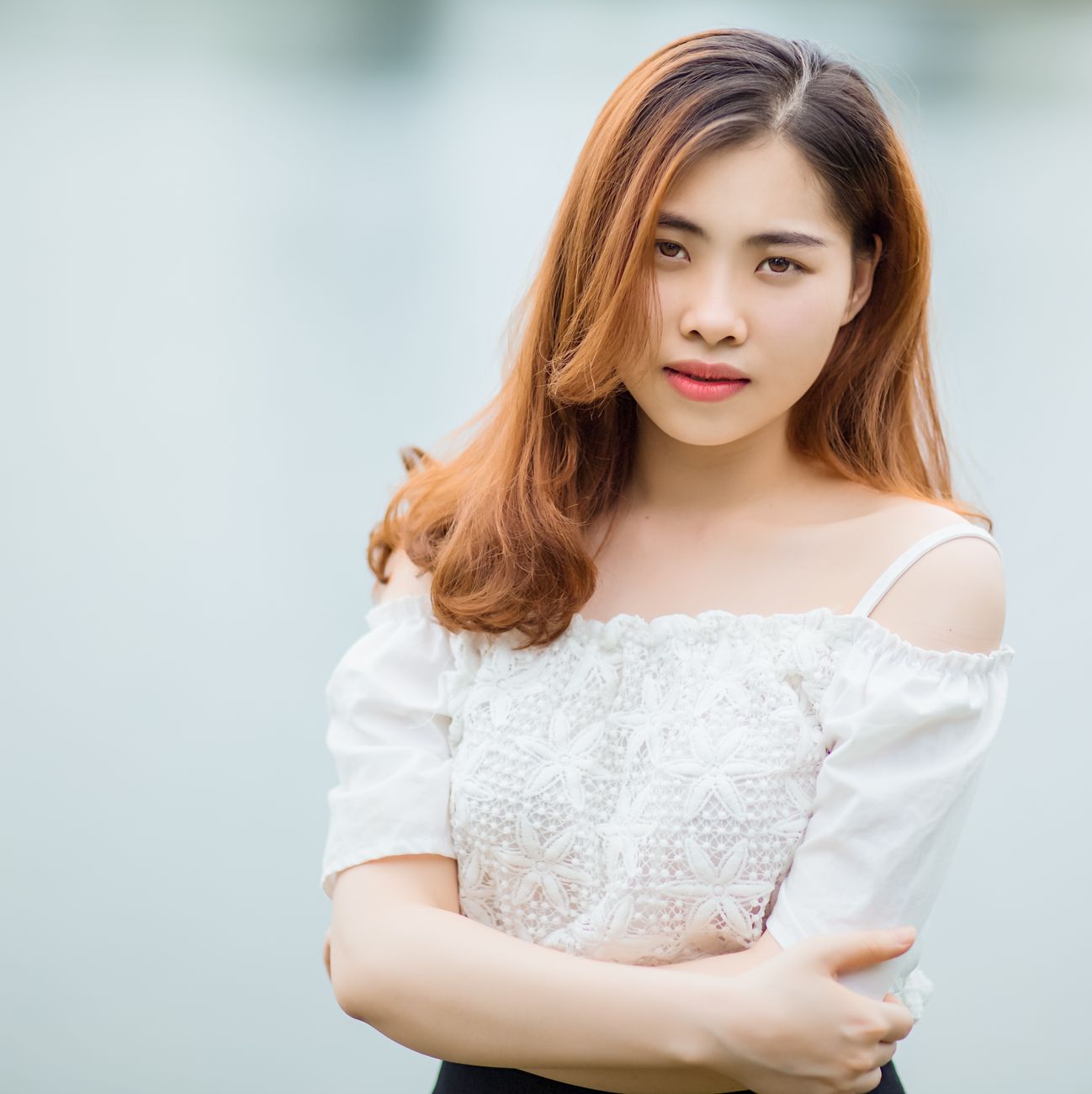 Portrait of a young woman in stylish outfit, exuding elegance and confidence outdoors.