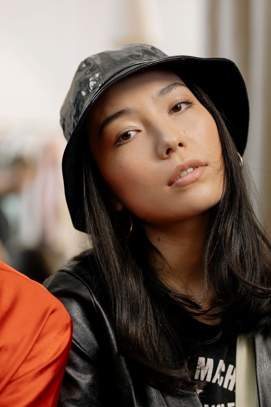 Stylish portrait of a woman wearing a trendy bucket hat, exuding elegance and confidence.