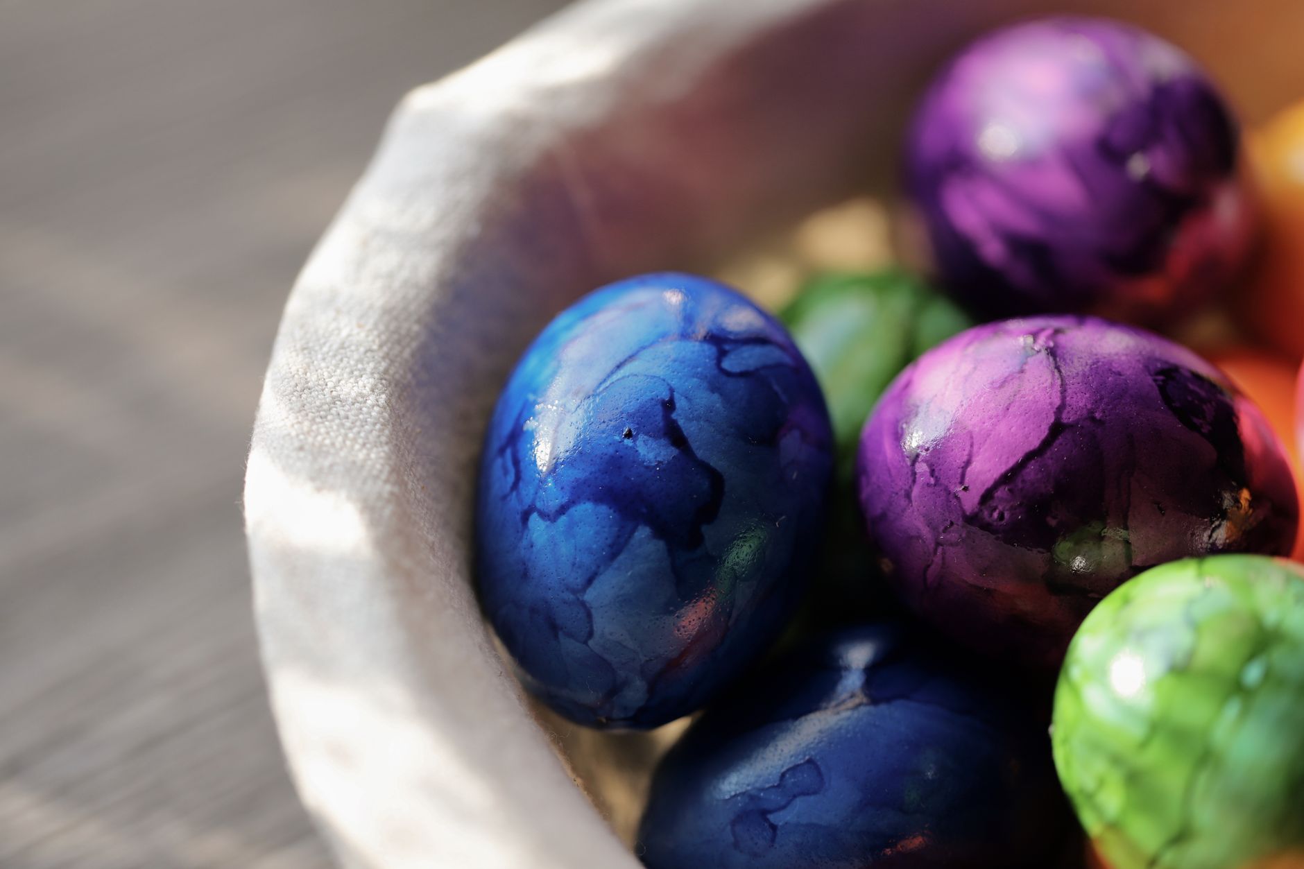 Close-up of colorful marbled Easter eggs in a soft basket, capturing the spring holiday spirit.