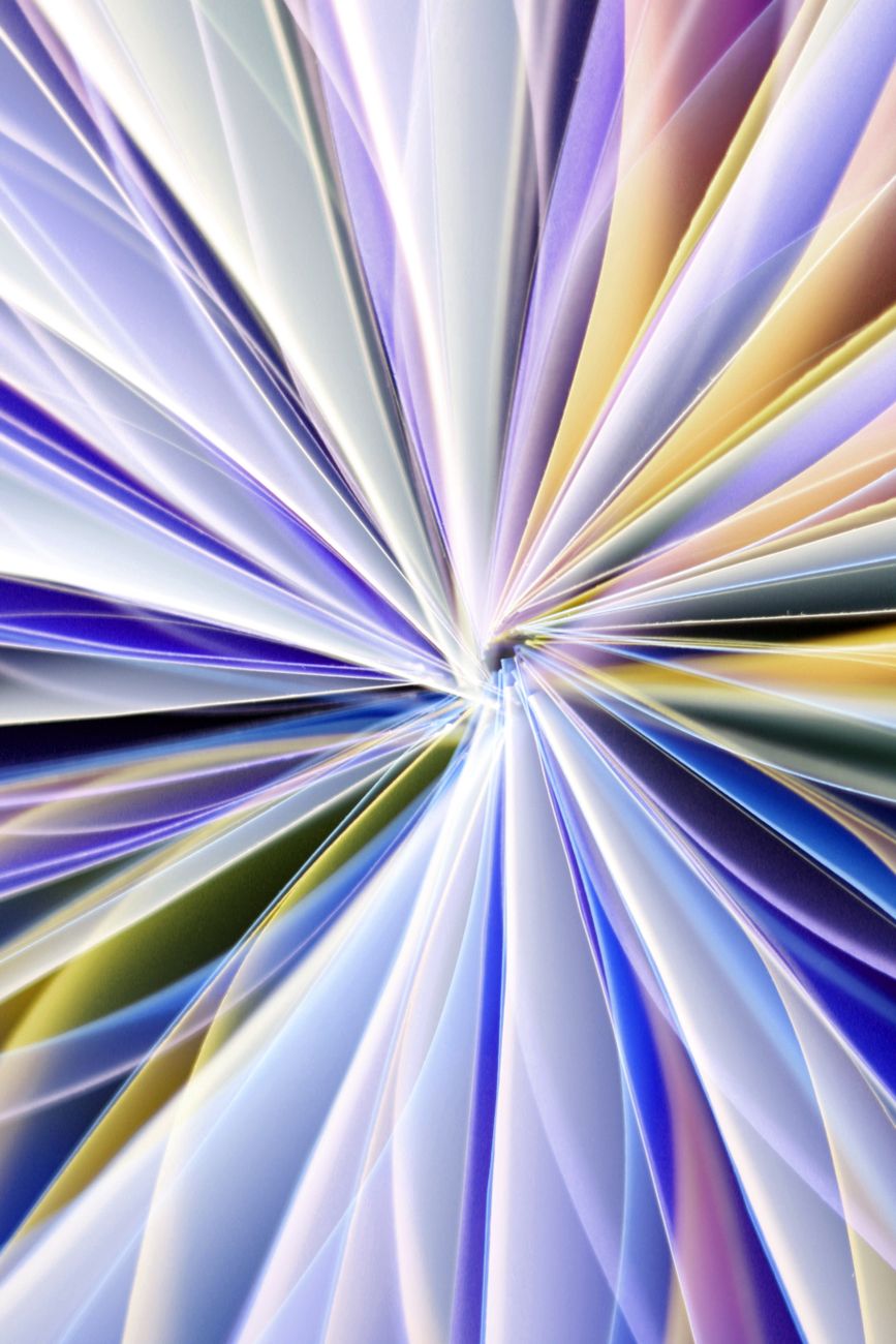 Dynamic abstract composition of folded paper creating a vibrant, multicolored pattern.