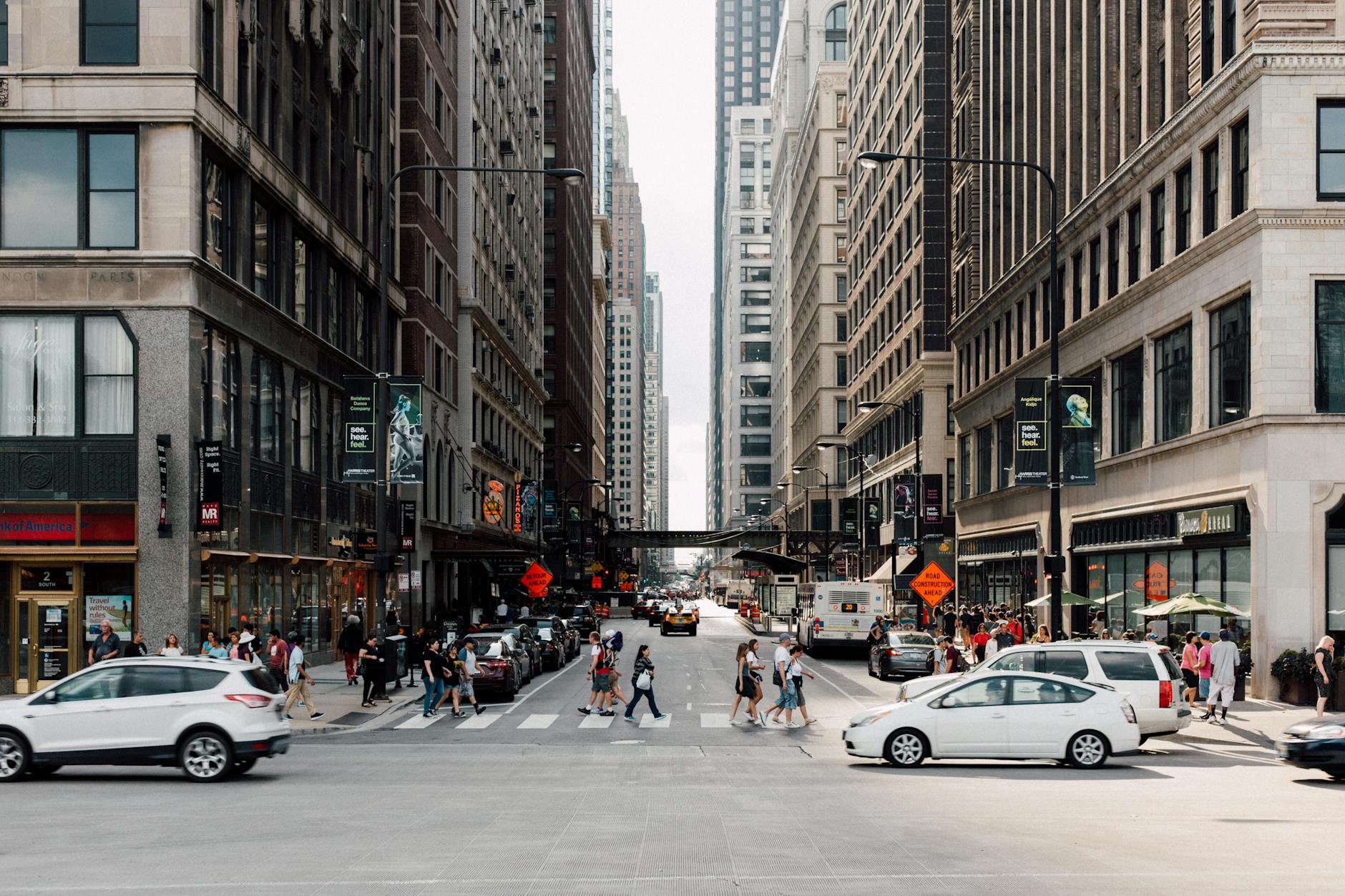 Dynamic cityscape showcasing pedestrians walking among skyscrapers and vehicles.