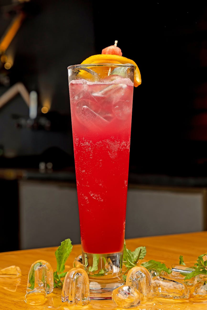 A vibrant red cocktail with citrus garnish, perfect for a refreshing drink.