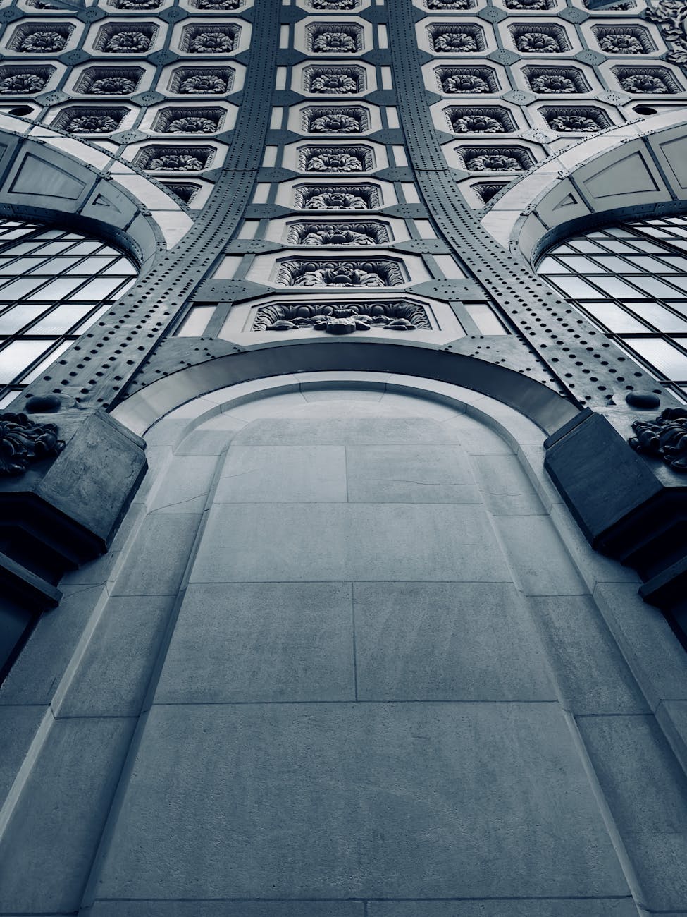 Upward view of a decorative archway with intricate designs and metal structures.