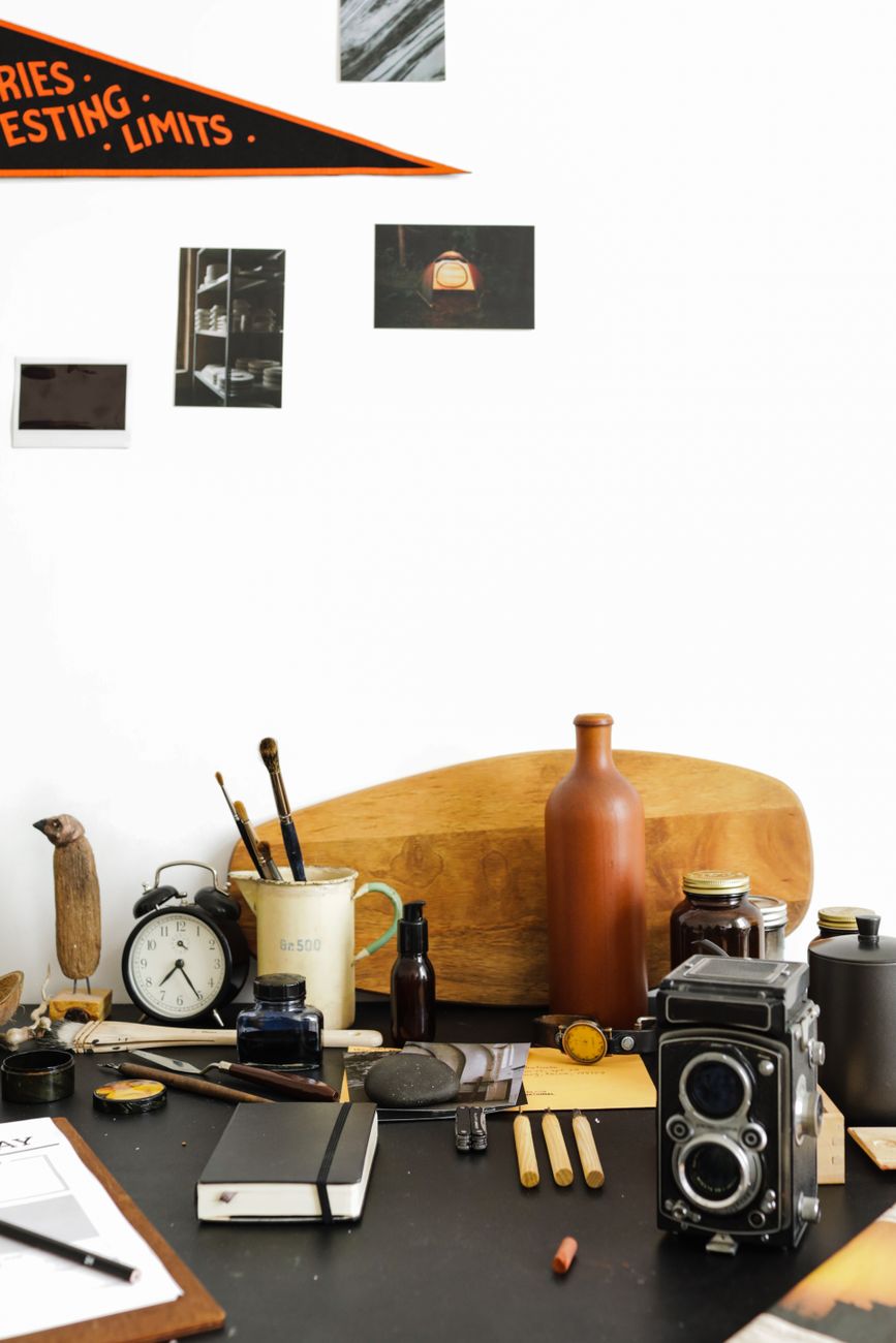 A stylish home office desk with vintage decor and camera, ideal for creative workspaces.
