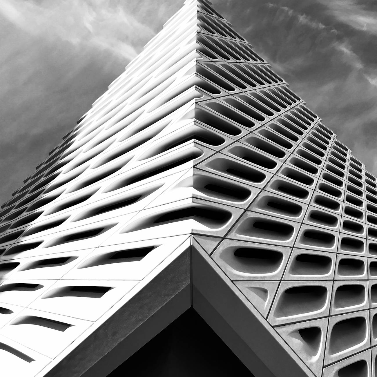 Striking black and white photo of a modern architectural building with unique geometric patterns.