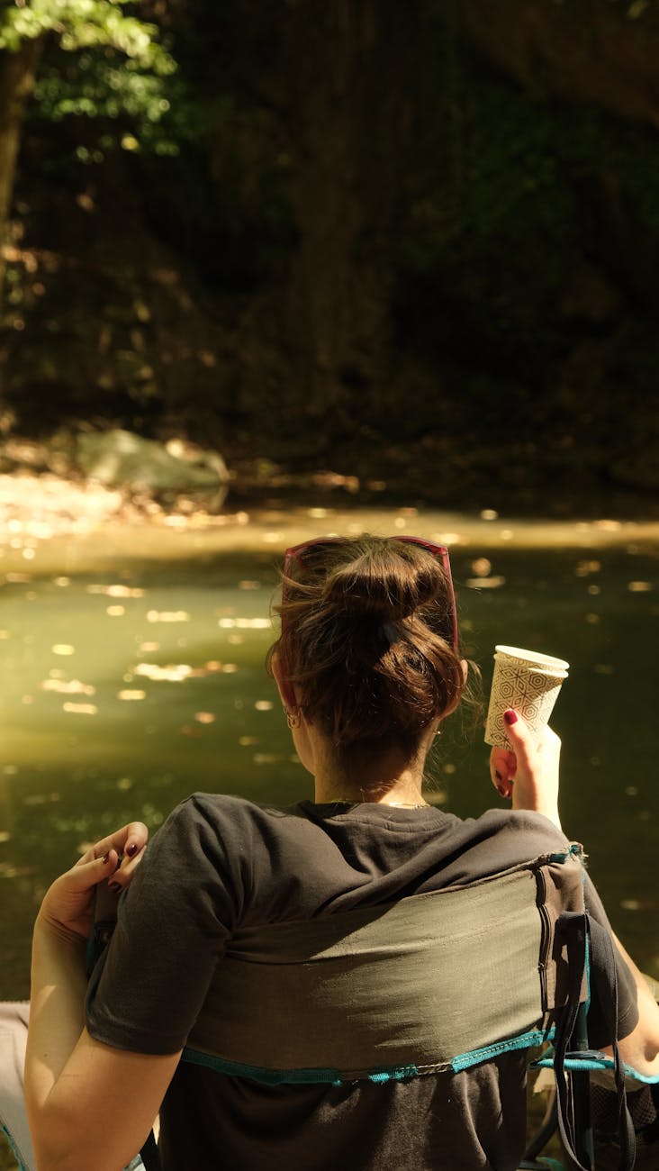 A woman relaxes by a tranquil lake enjoying nature in Istanbul, Turkey.
