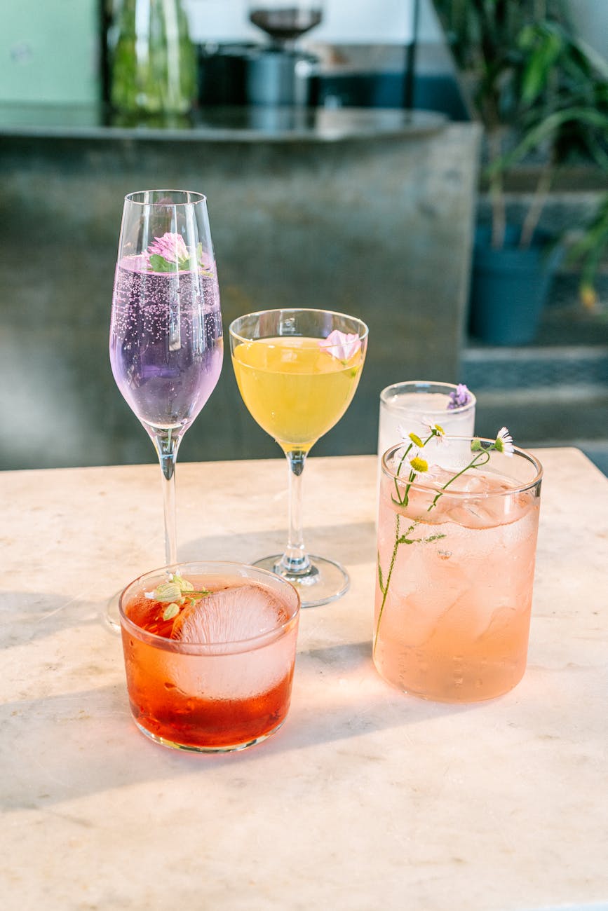 A vibrant selection of cocktails garnished with flowers, ideal for party and refreshment settings.