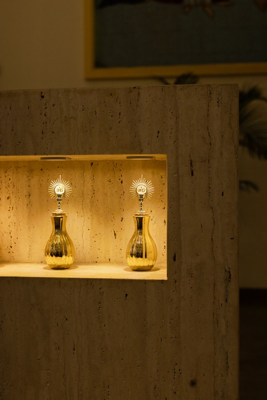 Golden religious artifacts beautifully displayed in a lit stone alcove.