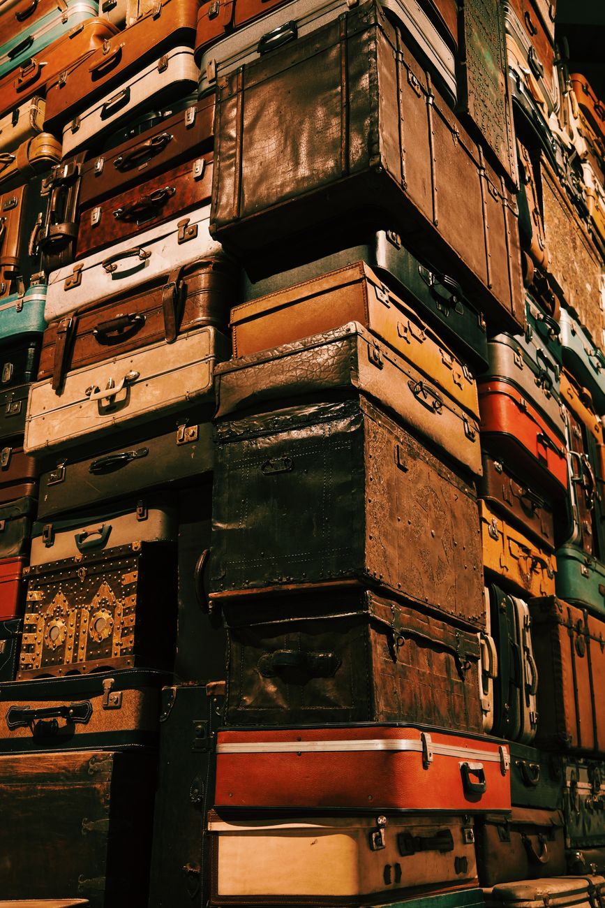 Towering pile of vintage suitcases representing travel and nostalgia.