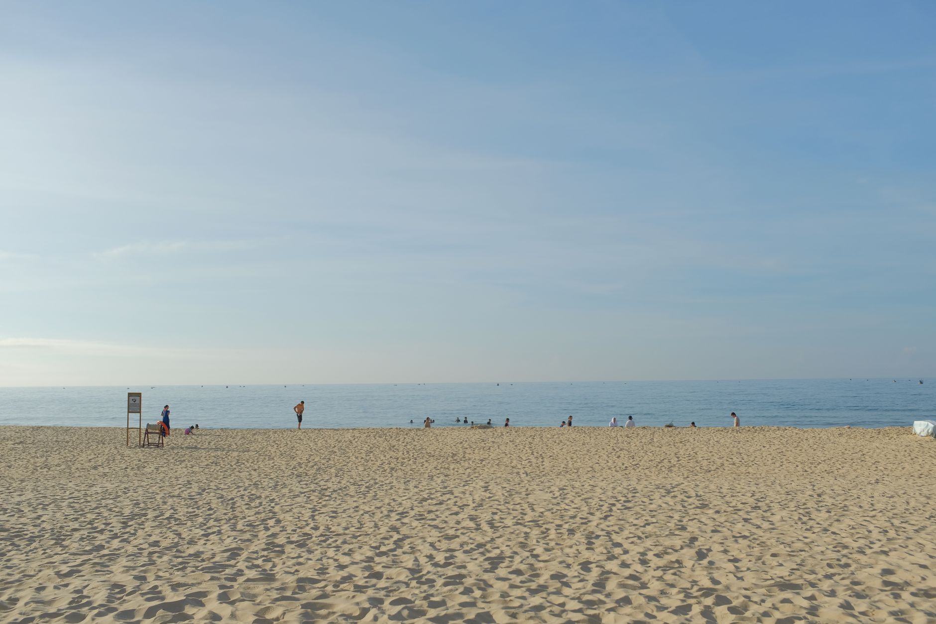 A peaceful beach day in Binh Thuan, Vietnam, with people enjoying the sunny atmosphere and calm sea.