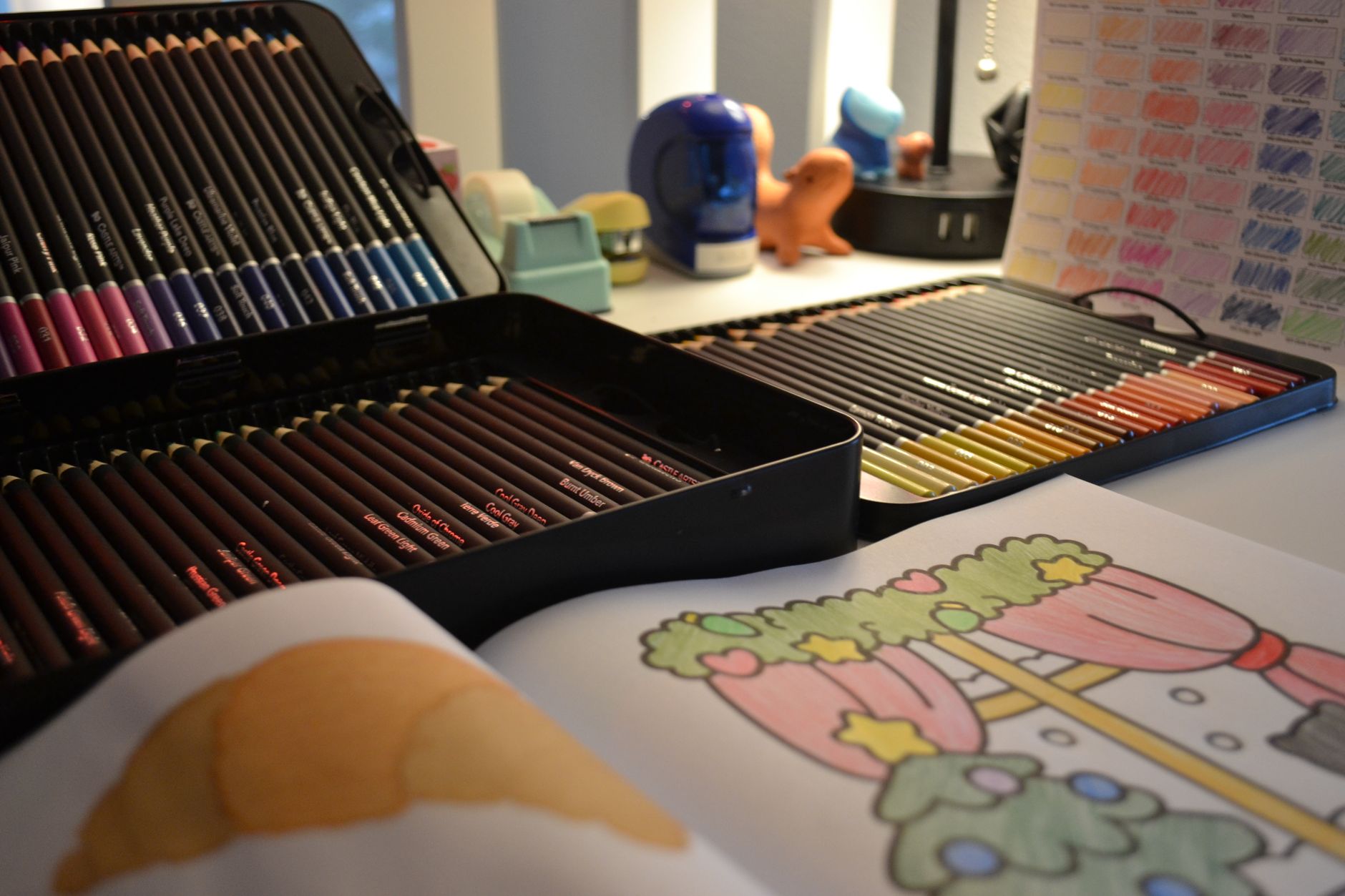 A creative workspace with coloring pencils, a coloring book, and various art supplies.