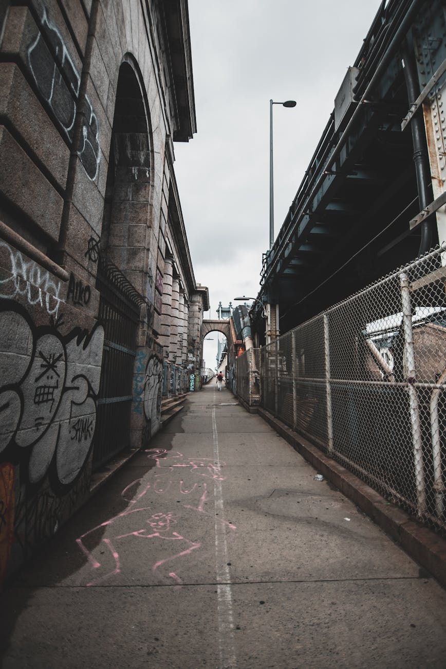 A gritty city alley in New York City with graffiti and architectural details.