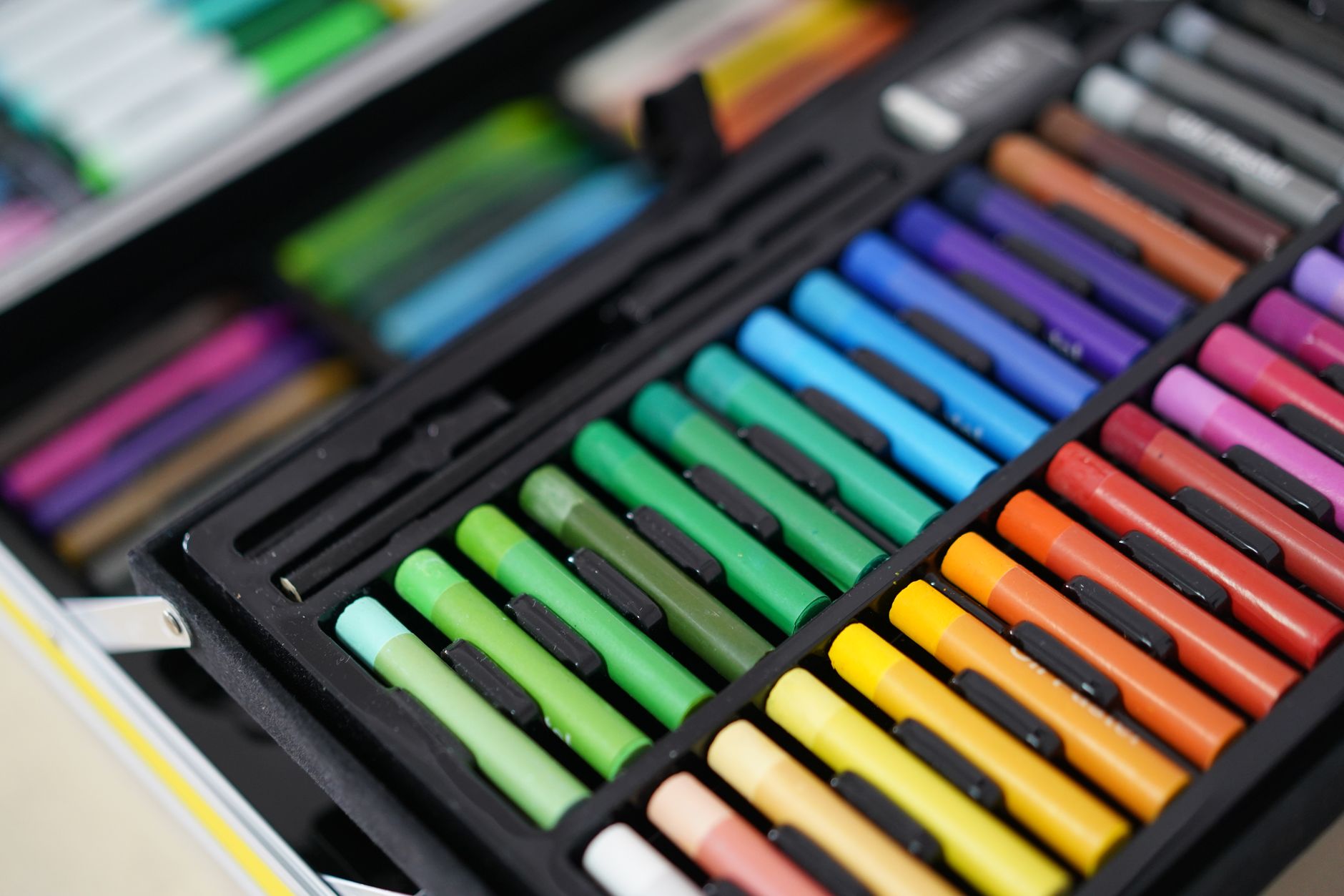 Close-up of a vibrant assortment of colorful art pastels neatly arranged in a case.