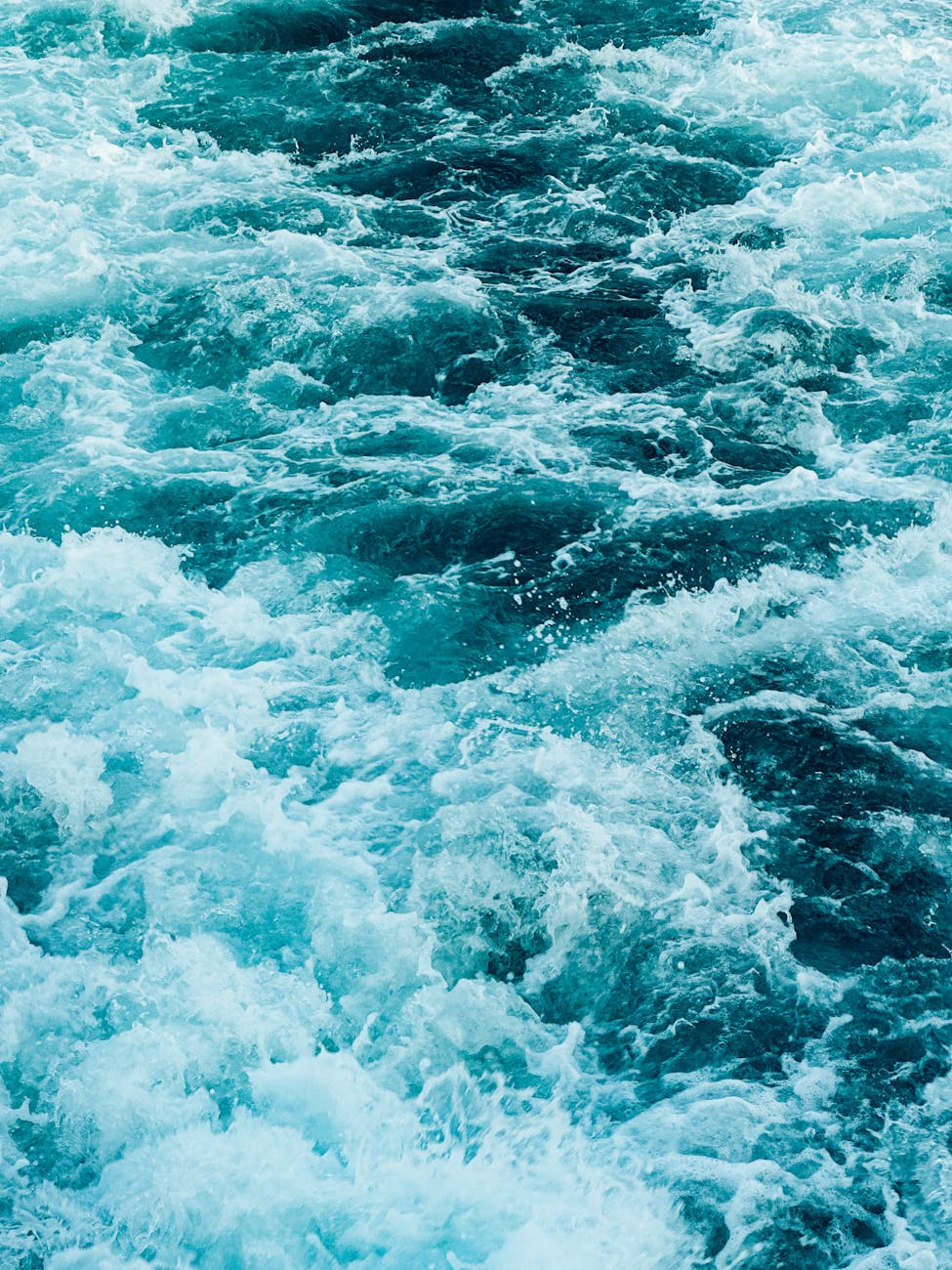 Energetic ocean waves forming beautiful patterns with vibrant aqua colors.