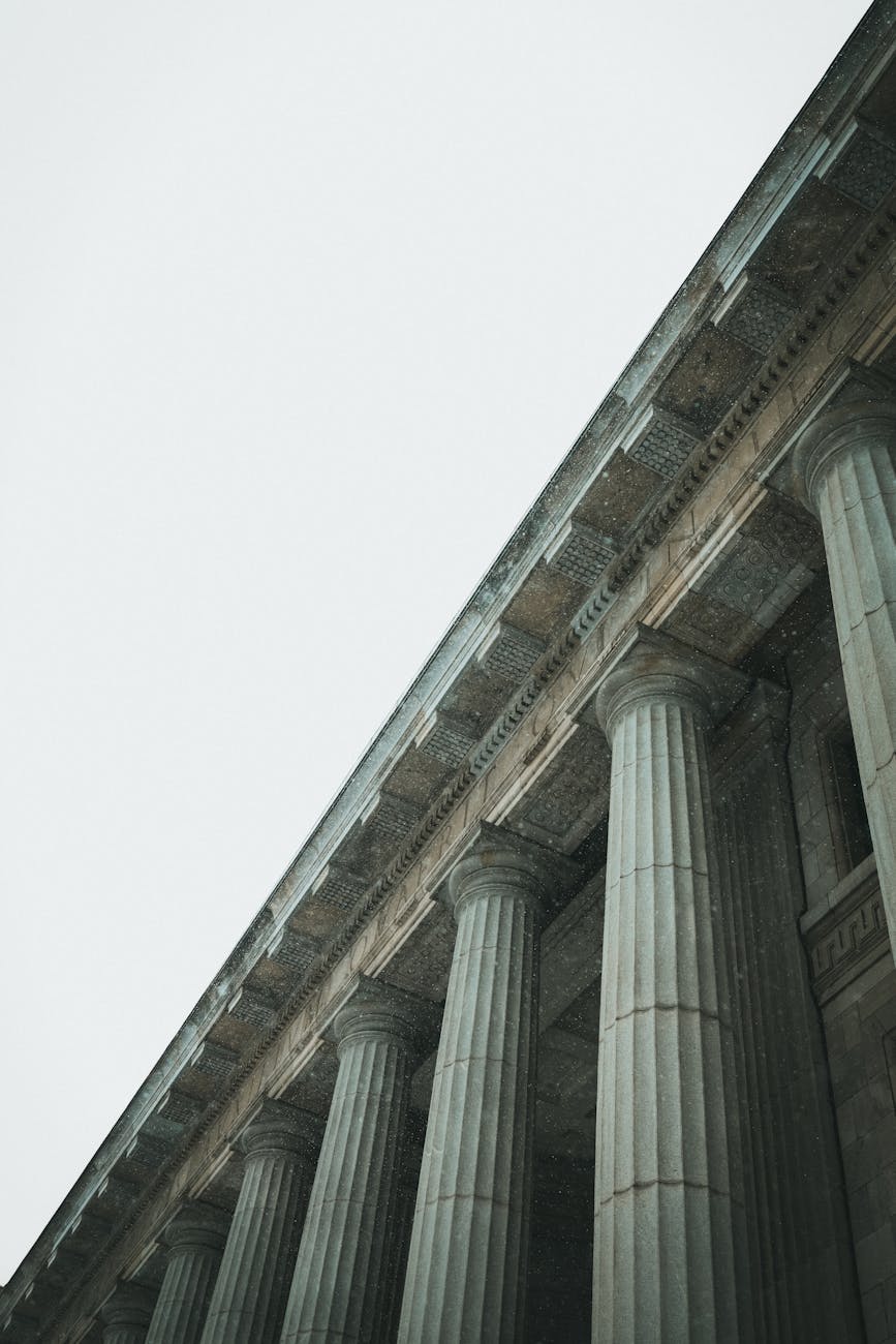 A low angle view of a series of grand classical columns in an architectural structure.