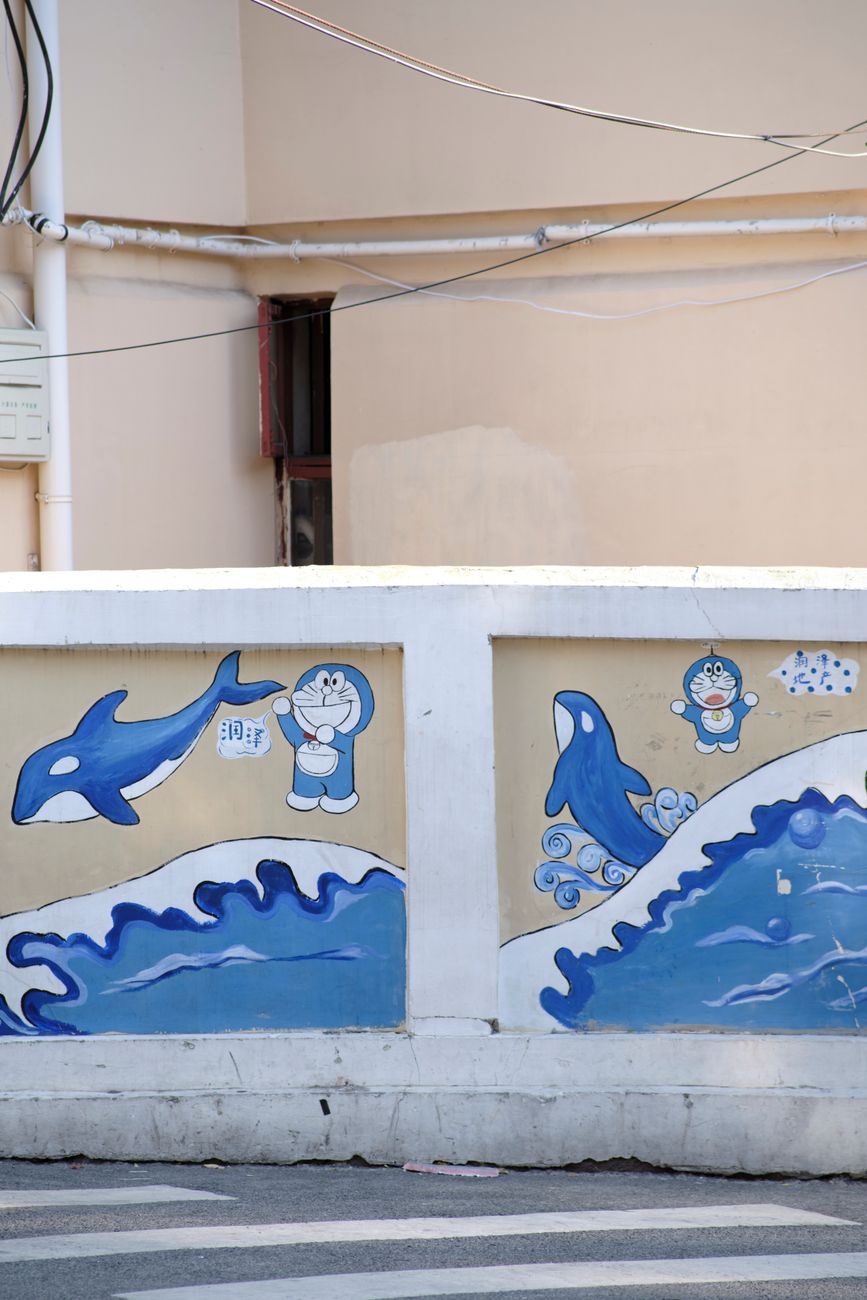 Vibrant urban wall mural featuring dolphins and cartoon figures in a city setting.