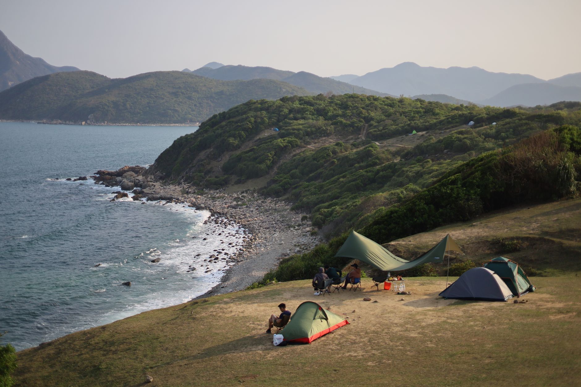 Aerial view of tents and campers on the scenic Hong Kong coastline.