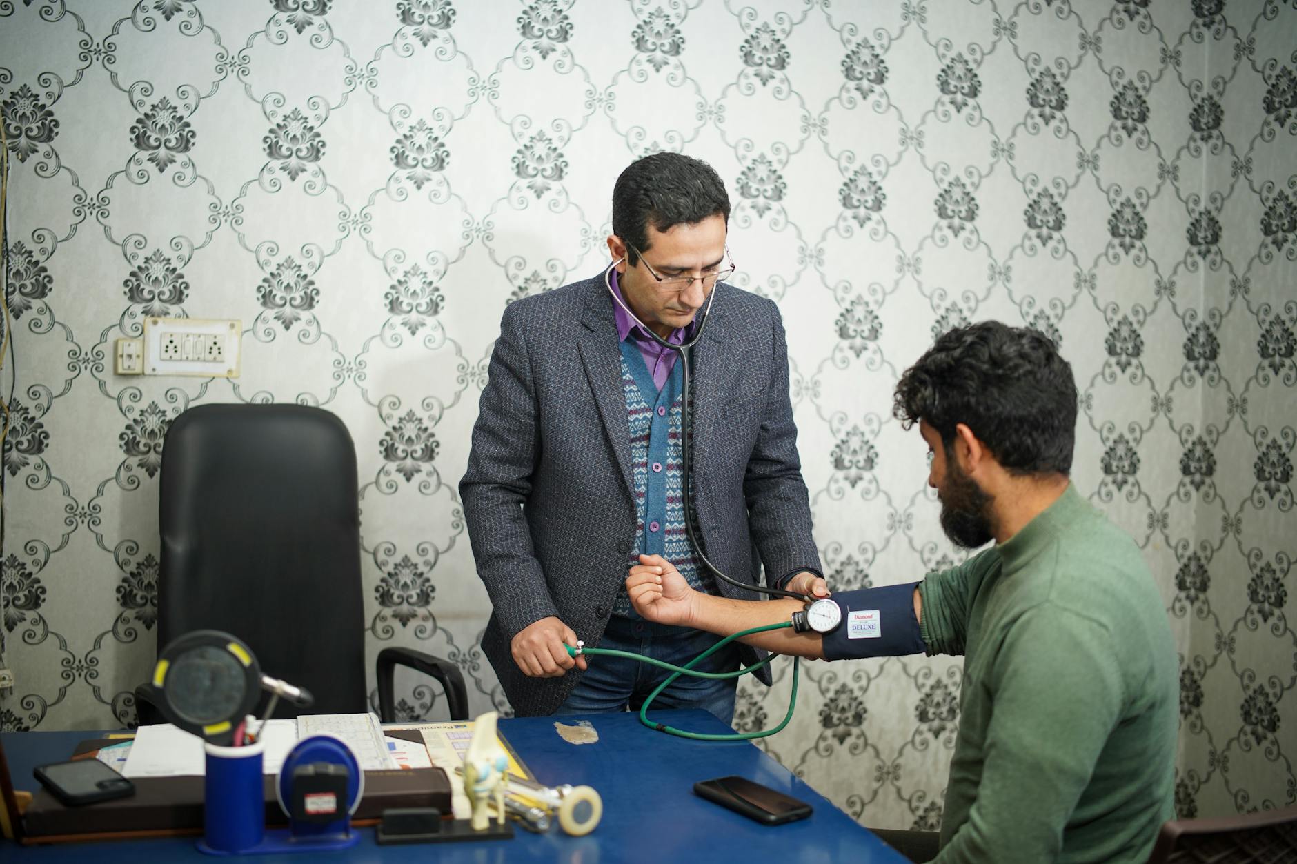 Doctor checking patient's blood pressure during medical consultation indoors.