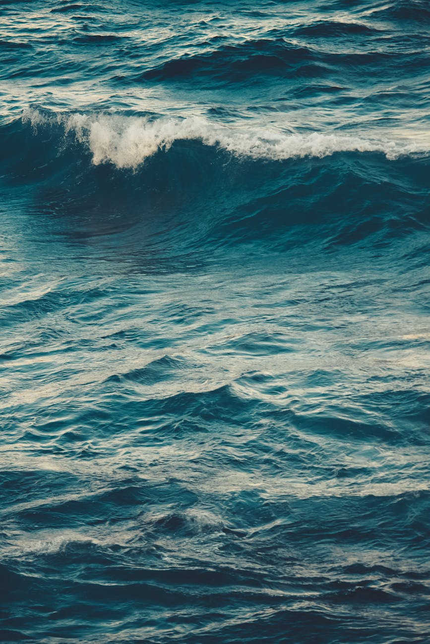 Vibrant ocean waves rolling on a windy day, captured in a vertical shot. Perfect for nature themes.