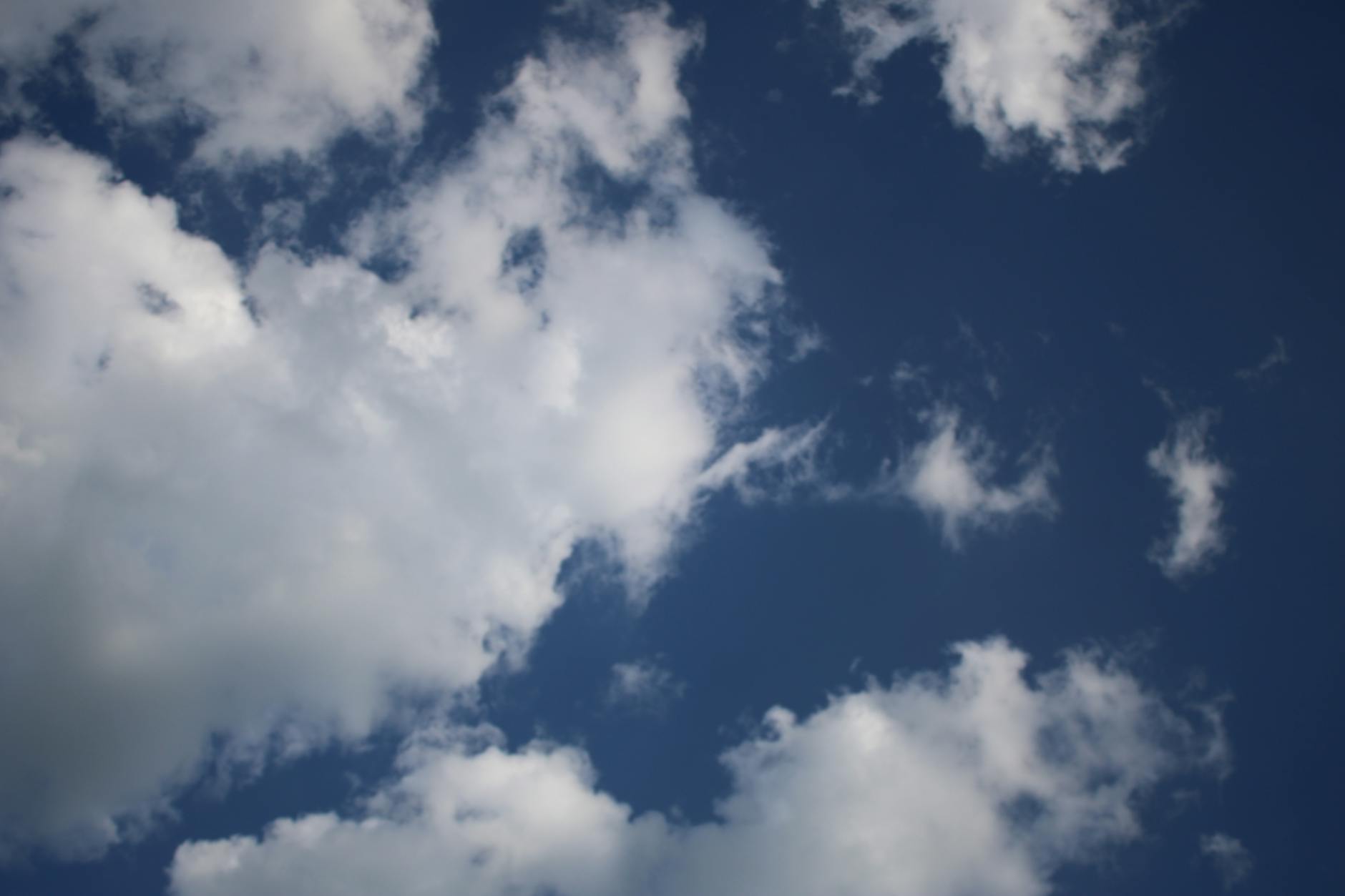 A serene view of fluffy white clouds against a deep blue sky, perfect for backgrounds.