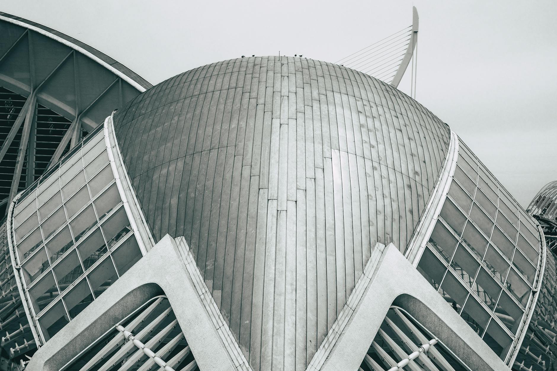 A striking futuristic building with a metallic dome and glass panels.