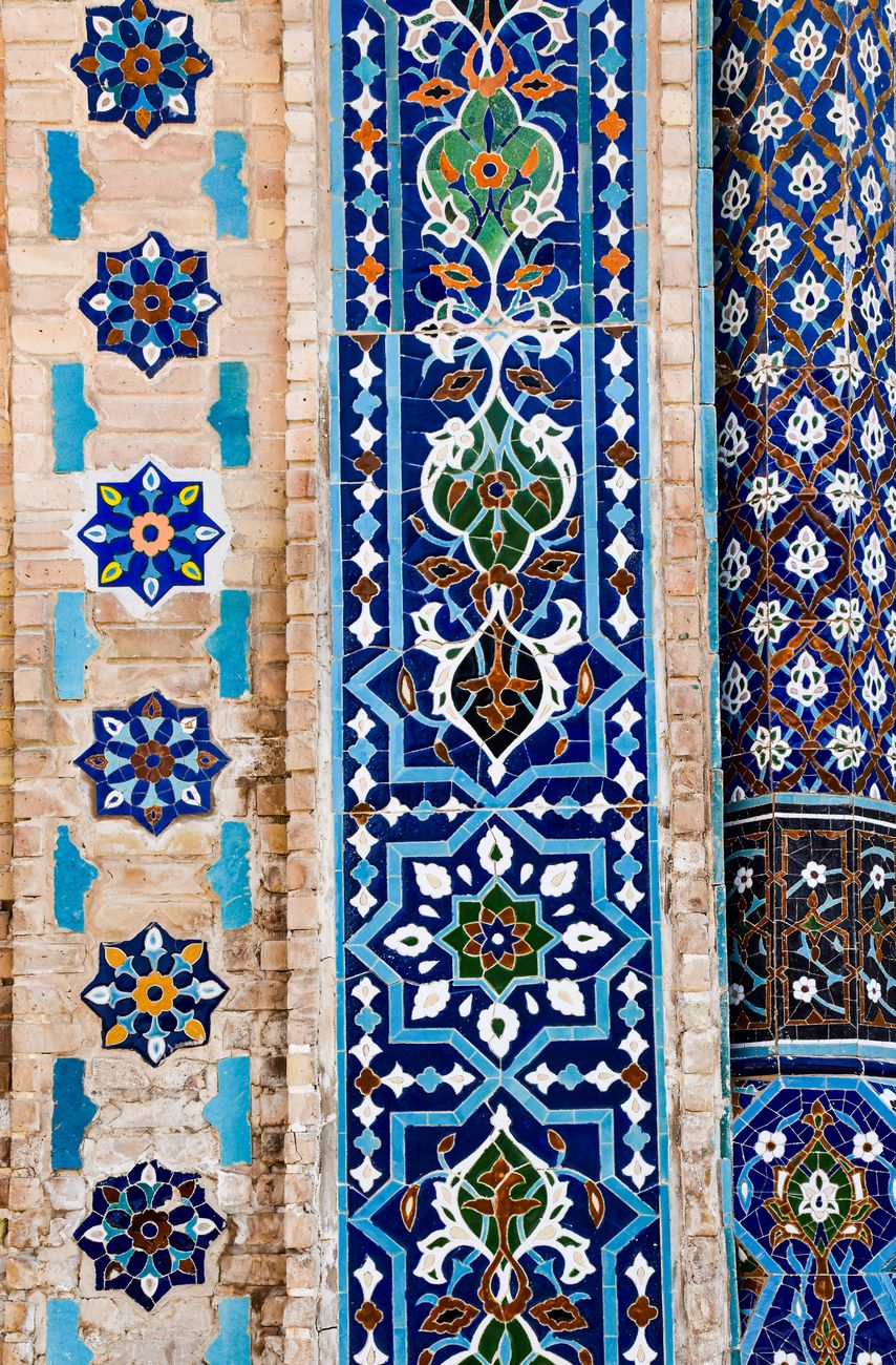 Detailed view of traditional Uzbek tile artwork on a decorative wall, showcasing intricate mosaic patterns.
