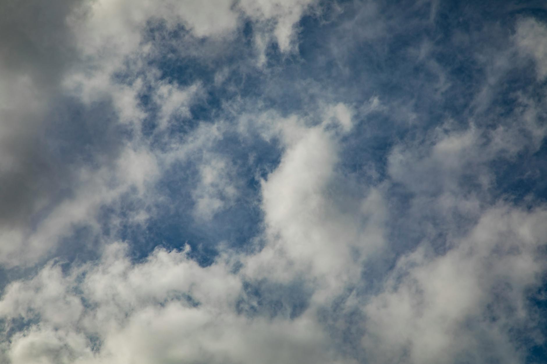 Fluffy clouds scattered across a vibrant blue sky, perfect for serene and dreamy designs.