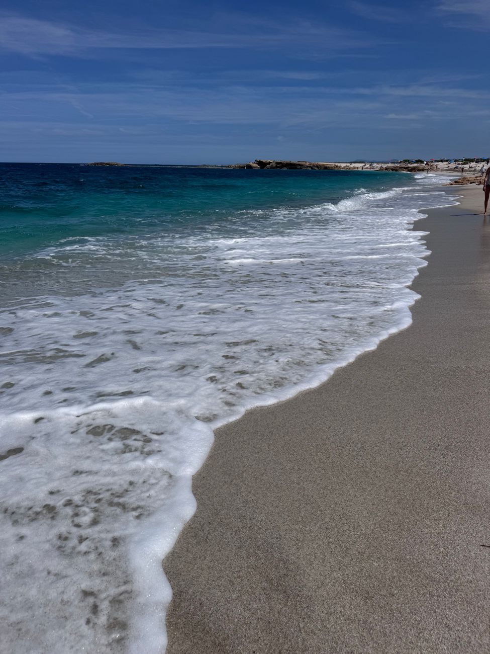 Experience the tranquil beauty of a sunny beach in Sardinia with gentle waves lapping against the shore.