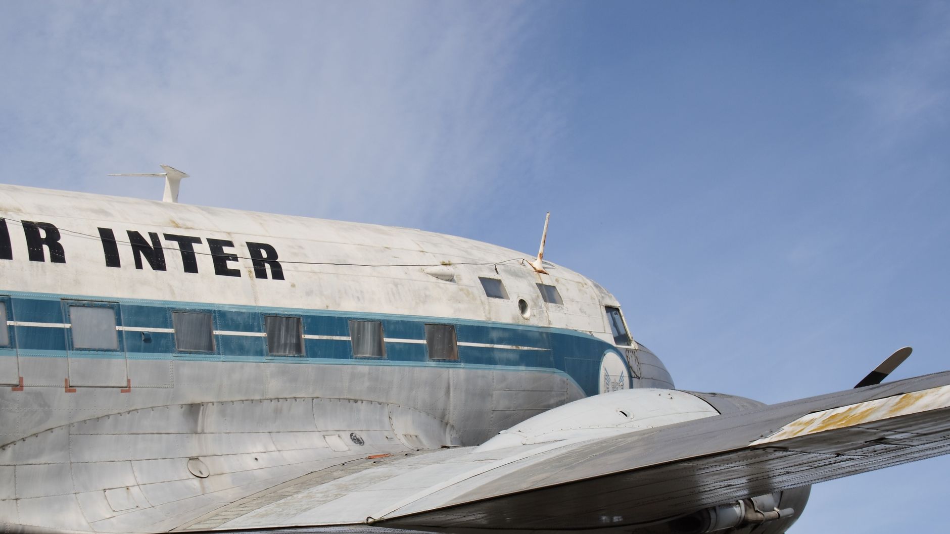Close-up of a vintage aircraft with visible propeller against a clear blue sky.