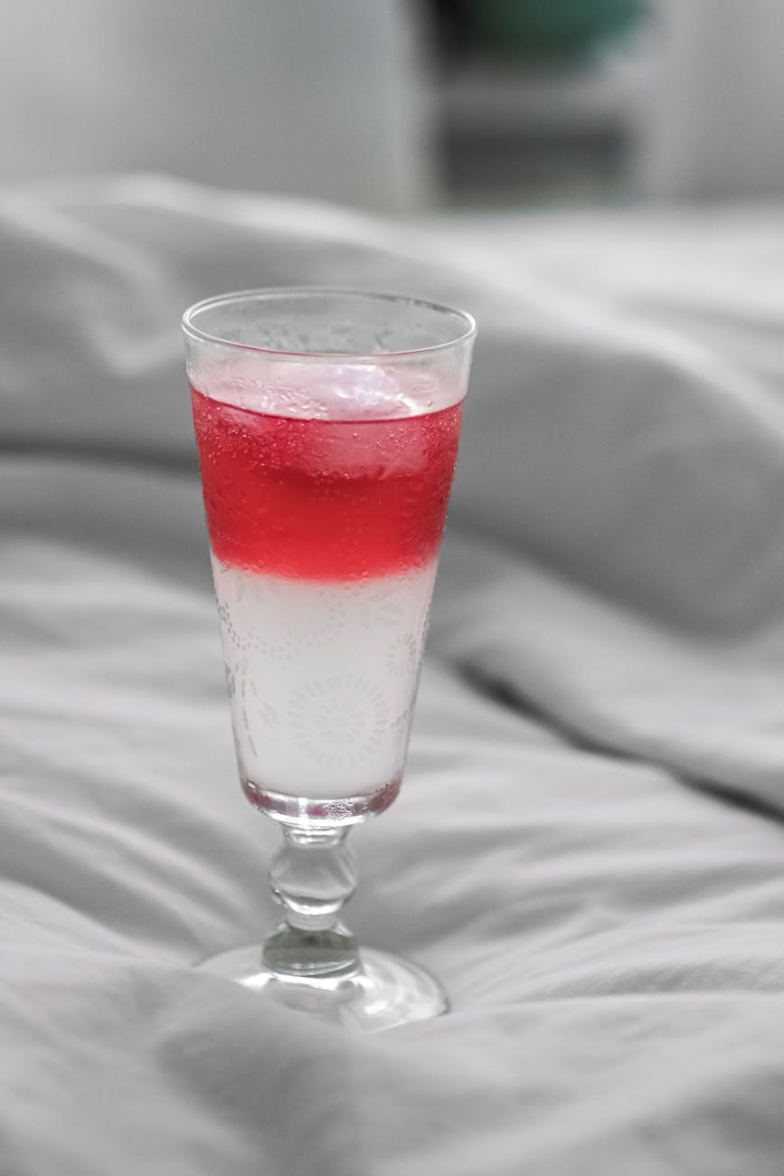 Chilled strawberry beverage with ice in a stylish glass, perfect for summer refreshment.