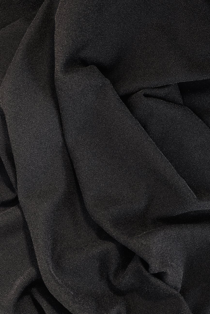 Close-up of elegant black fabric showcasing intricate textures and drapery folds.