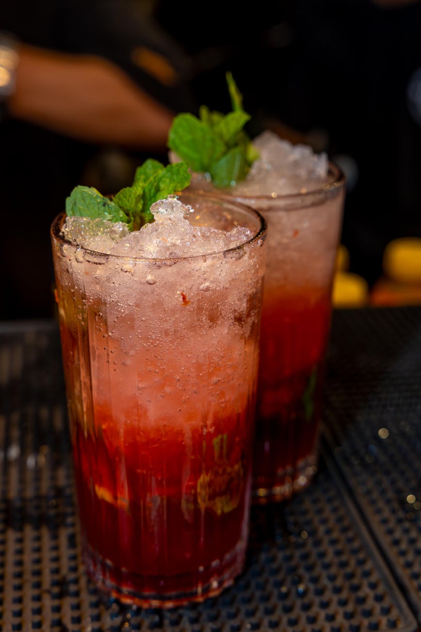 Two refreshing iced summer cocktails with mint garnish, perfect for a lively night out.