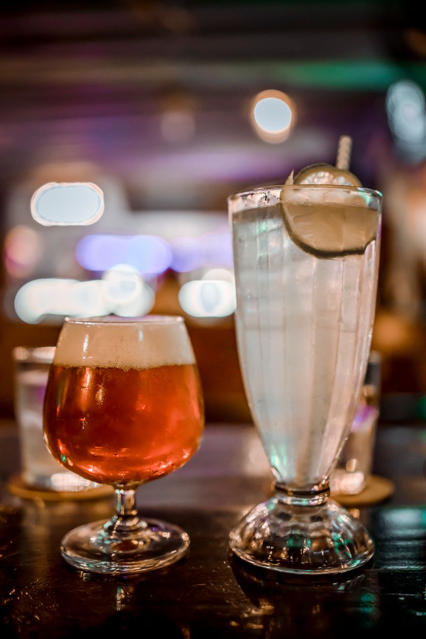Close-up of colorful cocktails on a bar counter in a cozy setting.