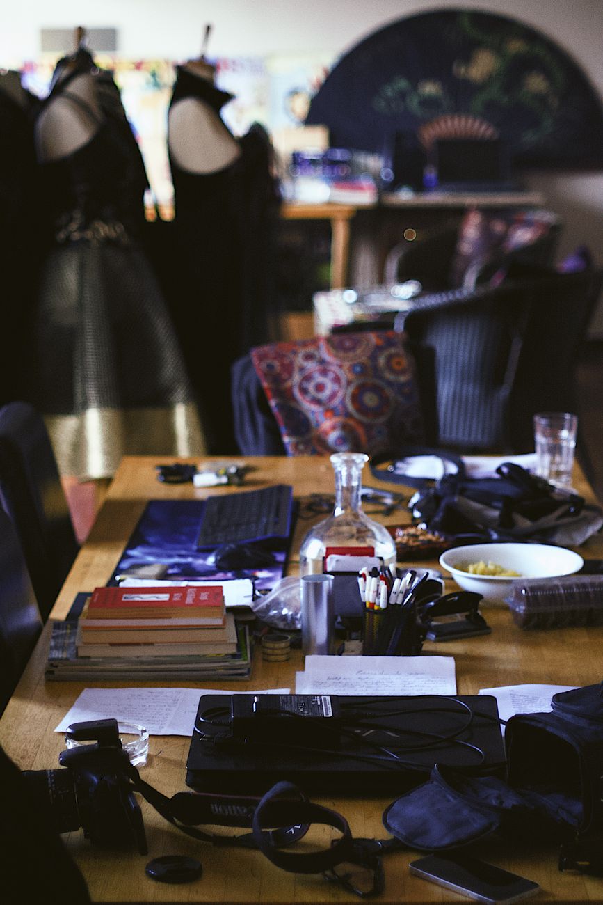 Explore a bustling fashion workshop filled with tools and fabrics, showcasing creative design elements.