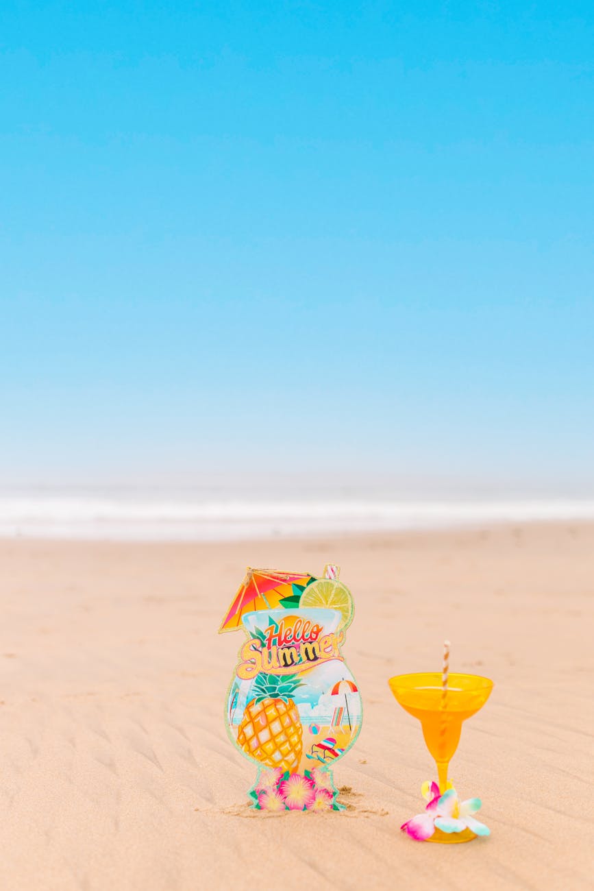 Colorful tropical drink on a beach with a summery backdrop, embodying summer vibes.