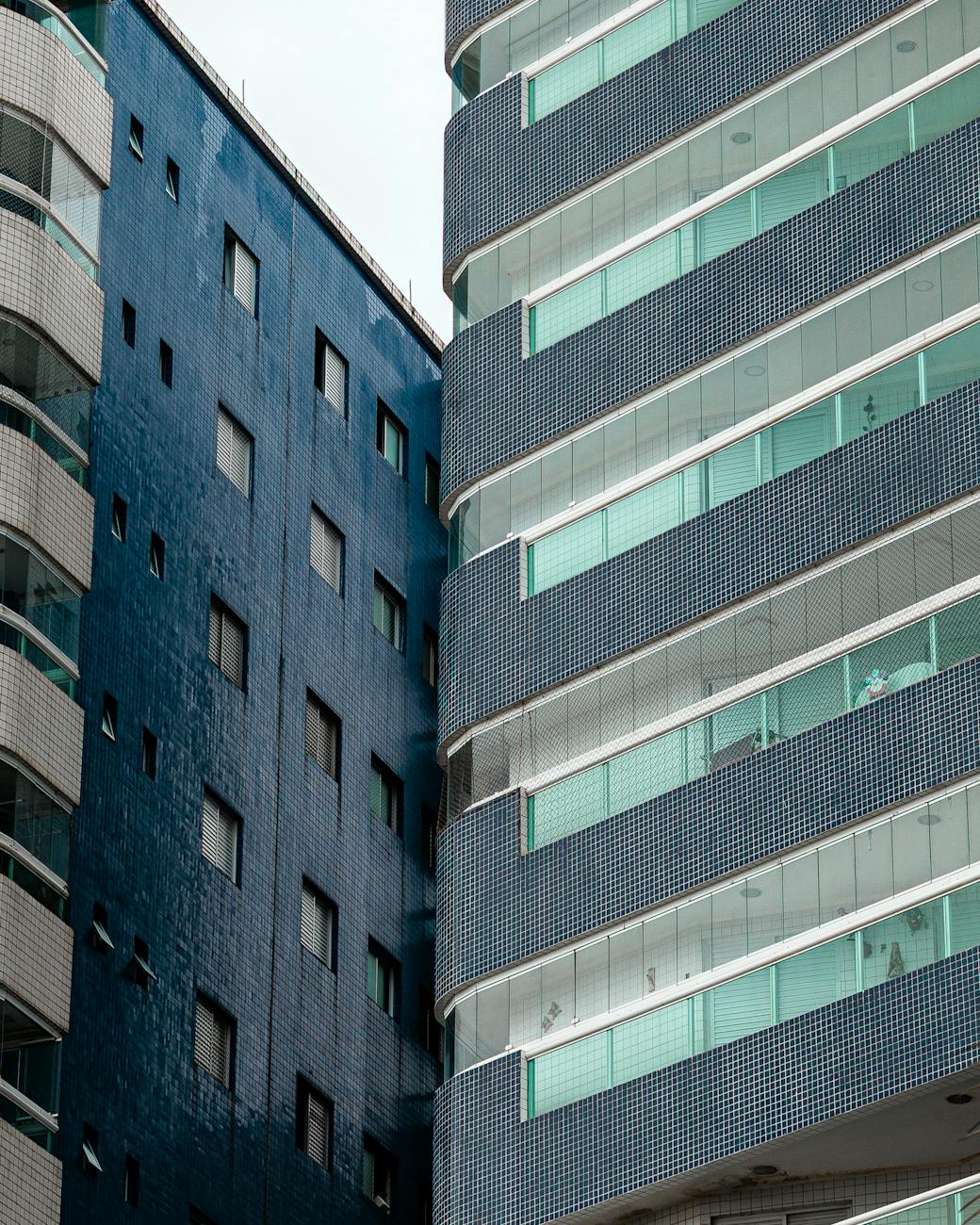 Close-up of modern buildings with glass balconies in an urban setting.