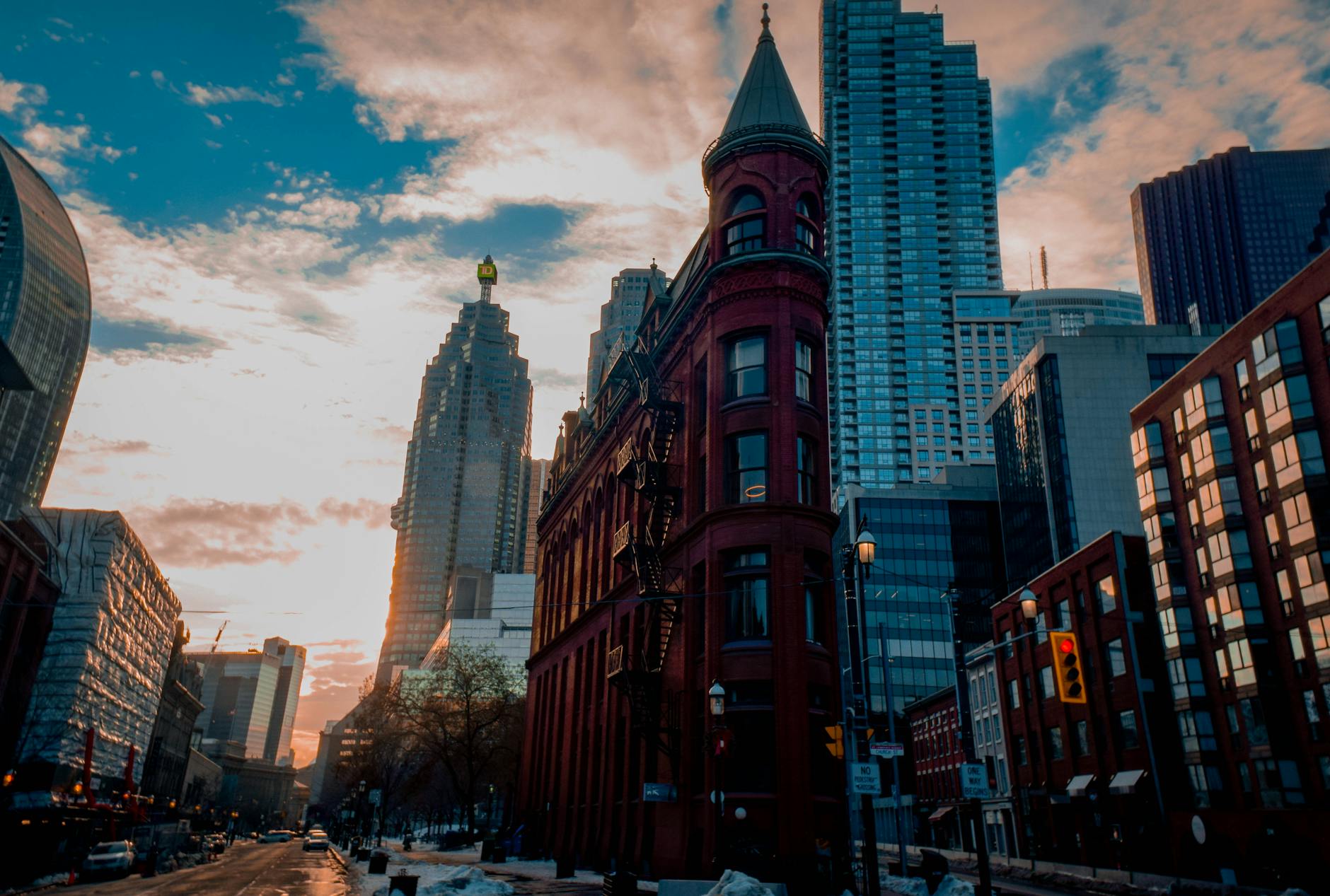 Beautiful winter sunset with Toronto's historic Flatiron Building surrounded by skyscrapers.